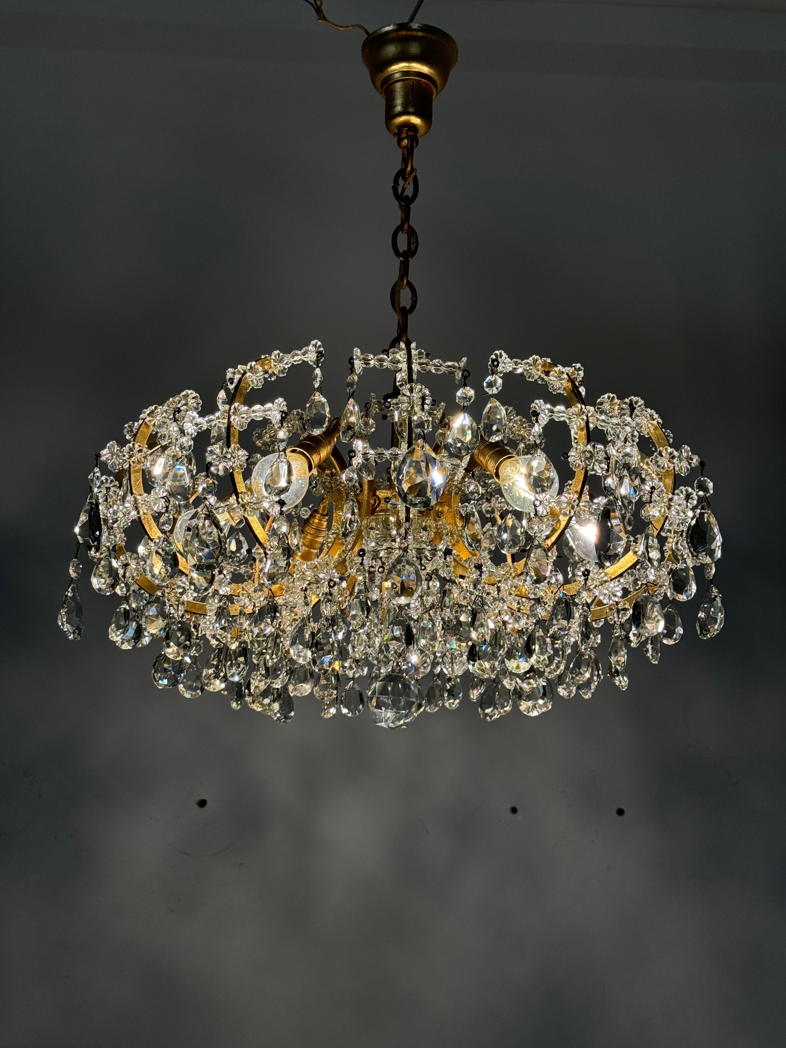 Lampadario in ottone e cristallo tagliato realizzato negli anni '60 probabilmente da Lobmeyr a Vienna.
Una bellissima cornice form A dipinta in oro. Sei fiammate dotate di prese E14, ricche di pendenti dai vari cristalli sfaccettati.