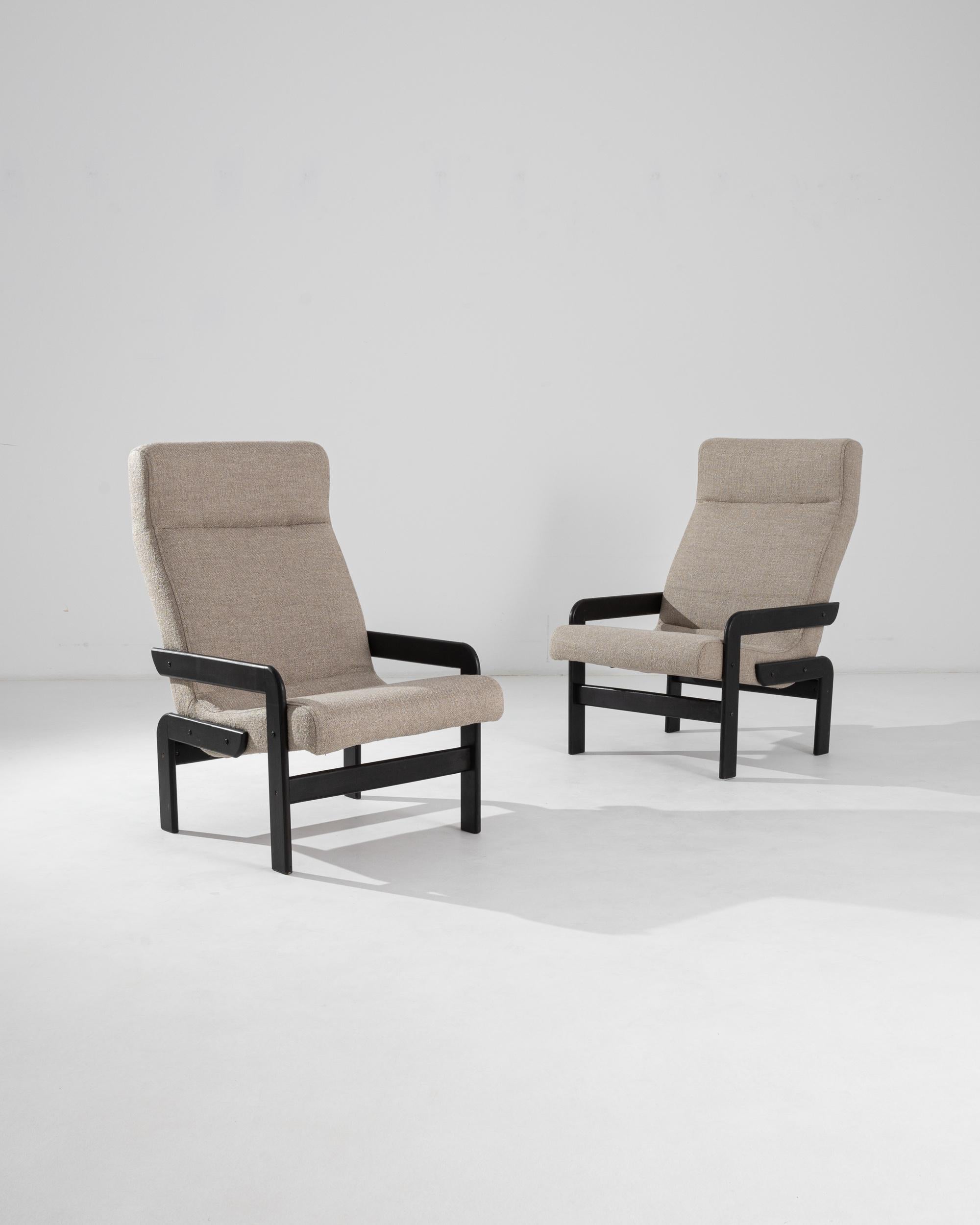 A unique silhouette in stylish black and tan gives this pair of vintage armchairs a Minimalist appeal. Made in Czechia in the 20th century, the pair allures with the perfect symmetry of their sleek lines. The chair’s arms and legs interact, but