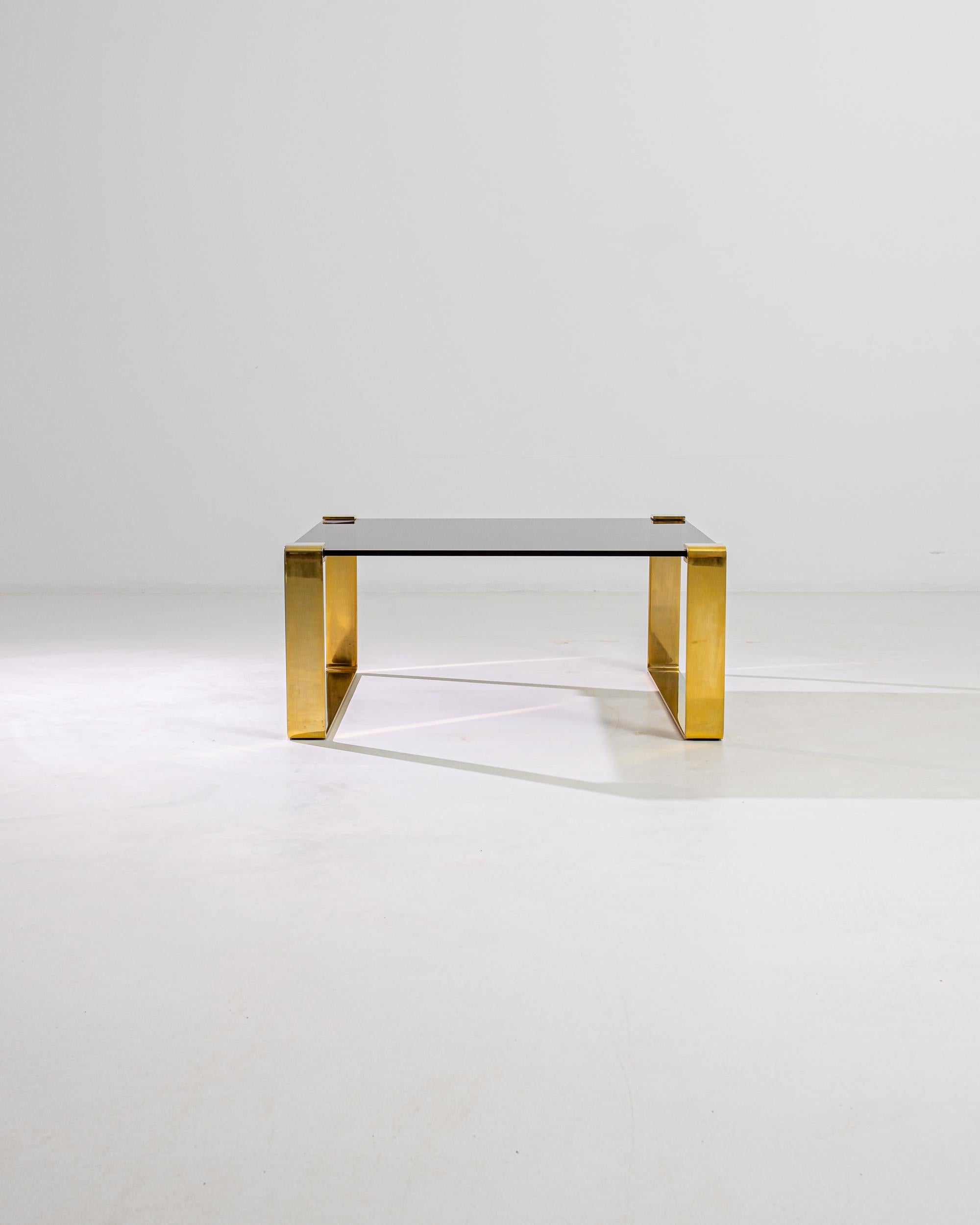Simple yet glamorous, this vintage coffee table pairs a stripped-back design with luxurious materials for an impression of minimalist opulence. Made in Denmark in the 20th century, a tabletop of semi-opaque glass is clasped within the brackets of