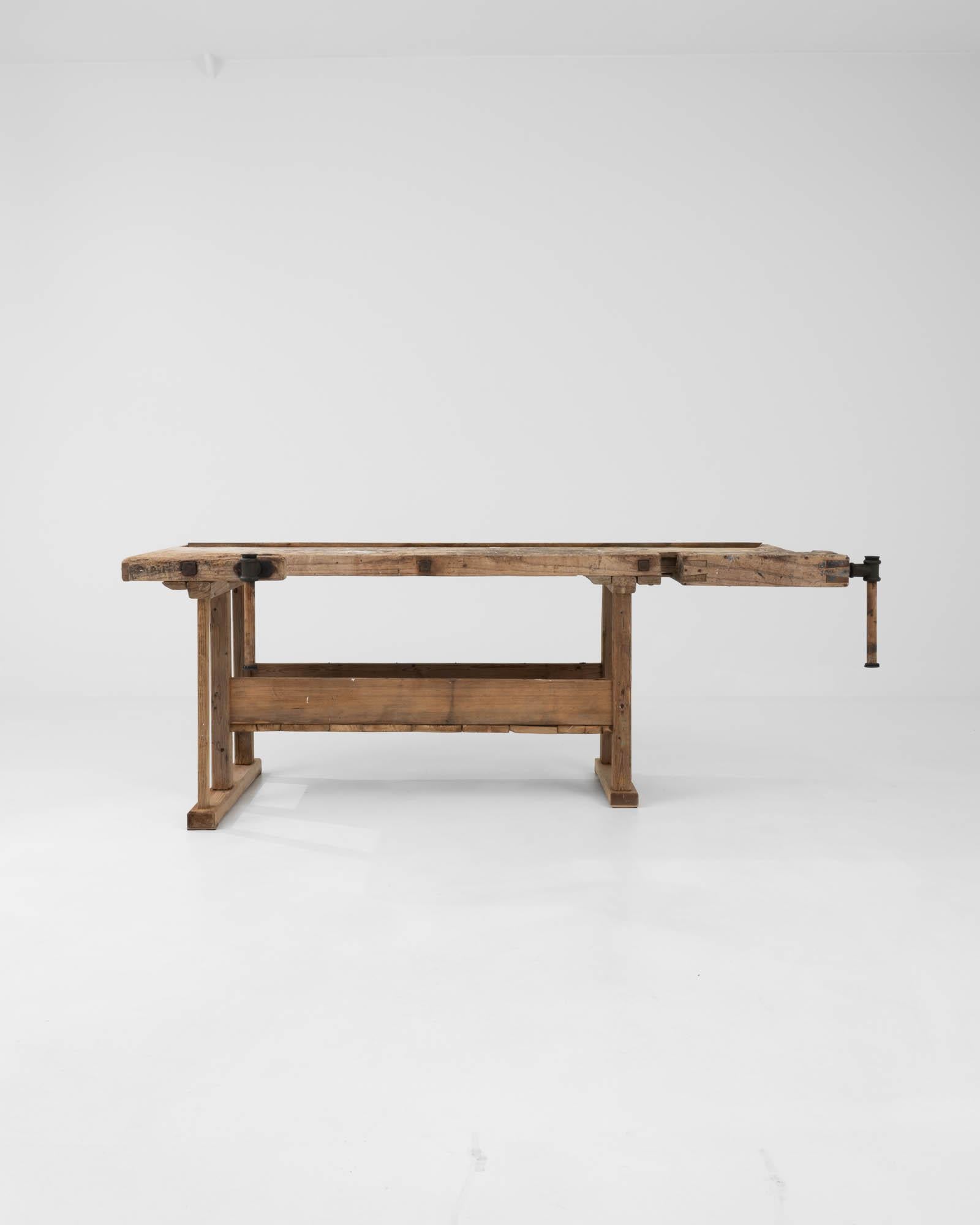 With its workmanlike design and warm natural finish, this vintage wooden table makes a striking Industrial accent. Built in Belgium in the 20th century, this piece would have originally been used as a carpenter’s work bench; the impressive metal