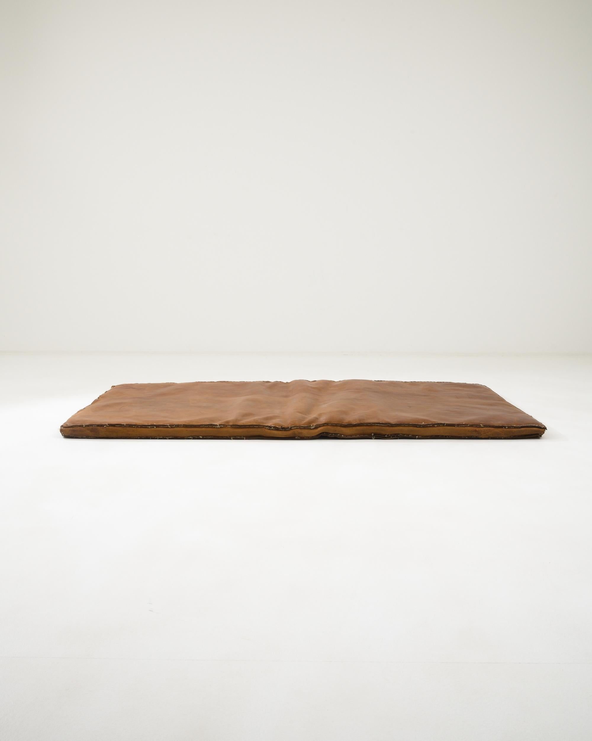 This unique mattress was handcrafted in the Czech Republic during the 20th century. The bold stitches along its edges infuse it with a distinctive character, while the caramel hue of its high-quality leather exudes a sense of warmth and coziness.