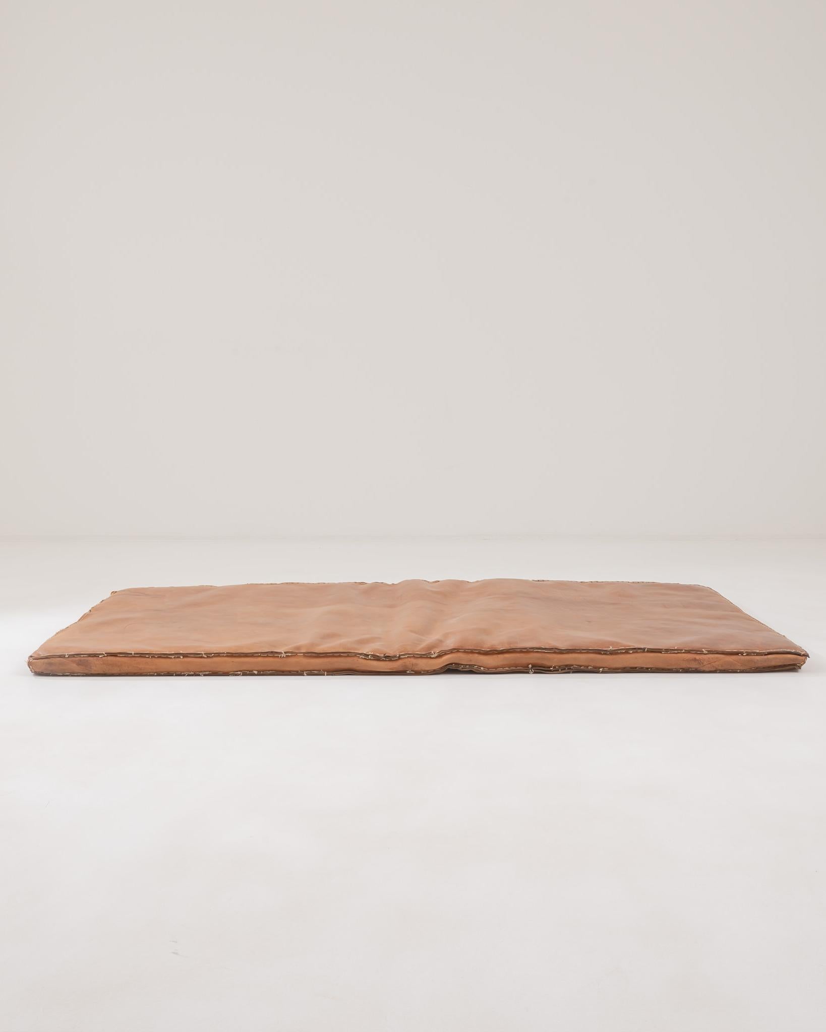 This unique mattress was handcrafted in the Czech Republic during the 20th century. The bold stitches along its edges infuse it with a distinctive character, while the caramel hue of its high-quality leather exudes a sense of warmth and coziness.