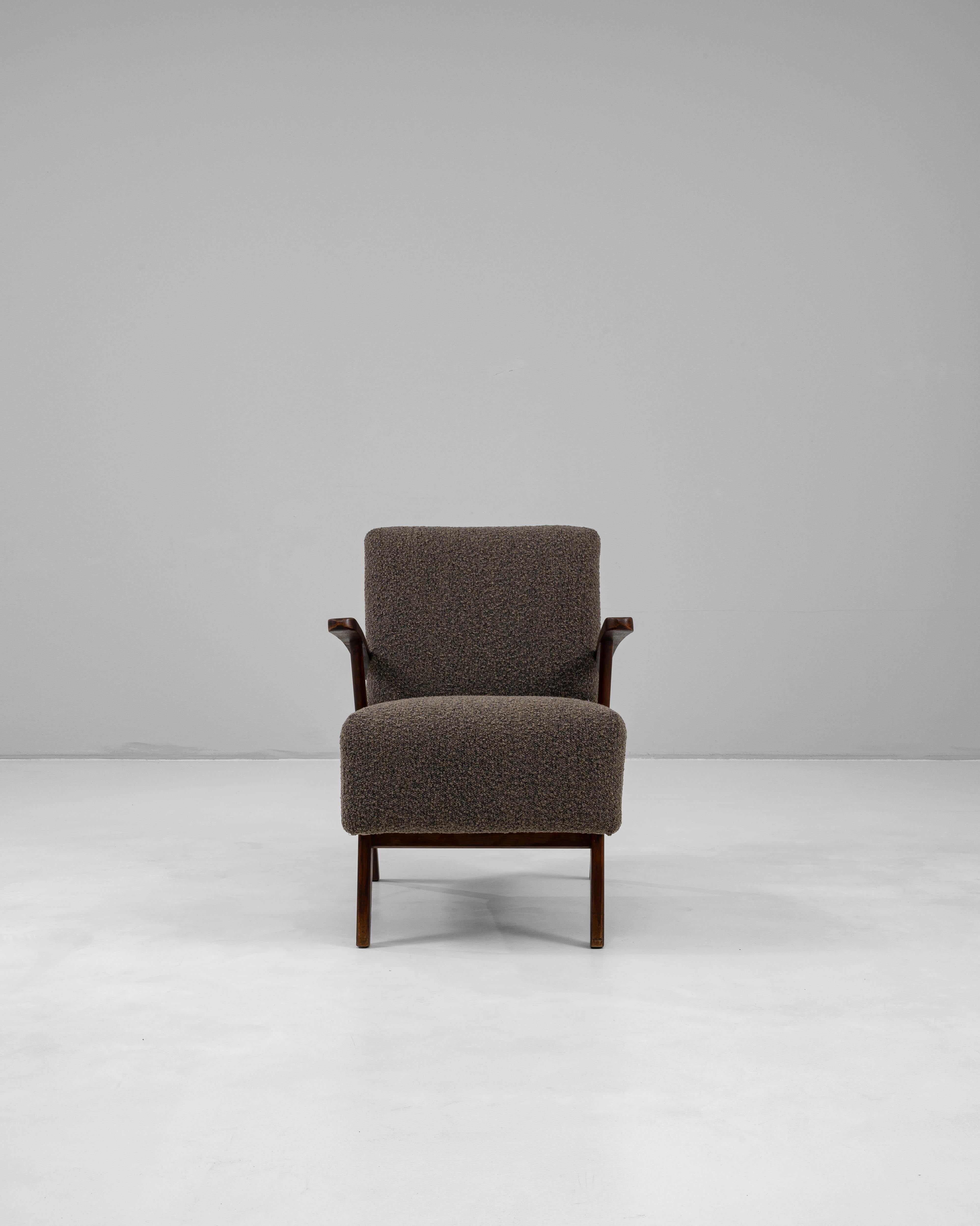 Este sillón tapizado checo de mediados del siglo XX captura las líneas limpias y la calidad escultórica características del diseño modernista europeo. El armazón está fabricado en madera de tonos cálidos, con patas en ángulo y reposabrazos