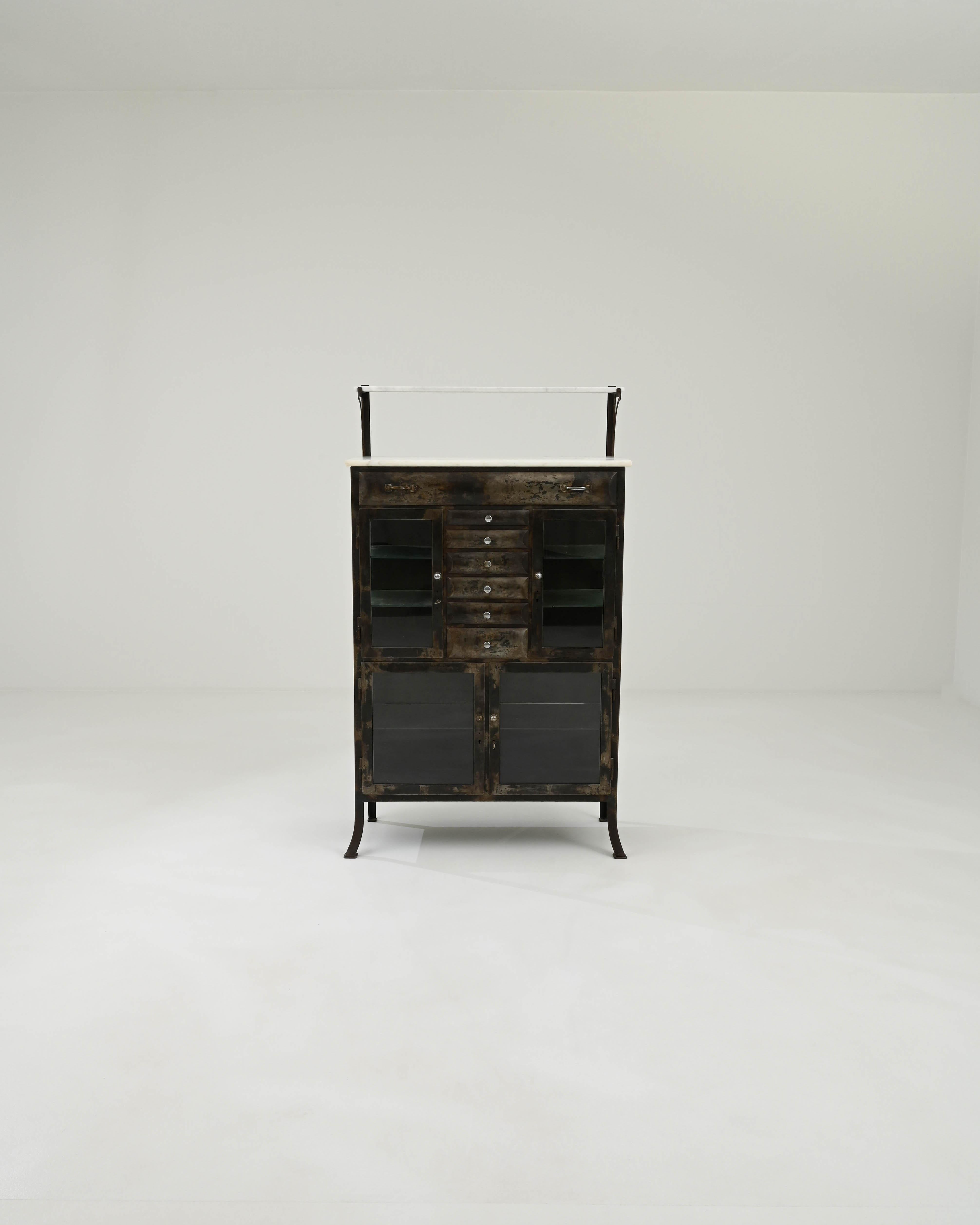 A metal vitrine created in 20th century Czechia. Industrial yet refined, this one of a kind display cabinet invokes a sense of delicately organized poise and timeless history. The weathered and patinated metal creates a dazzling array of hues and