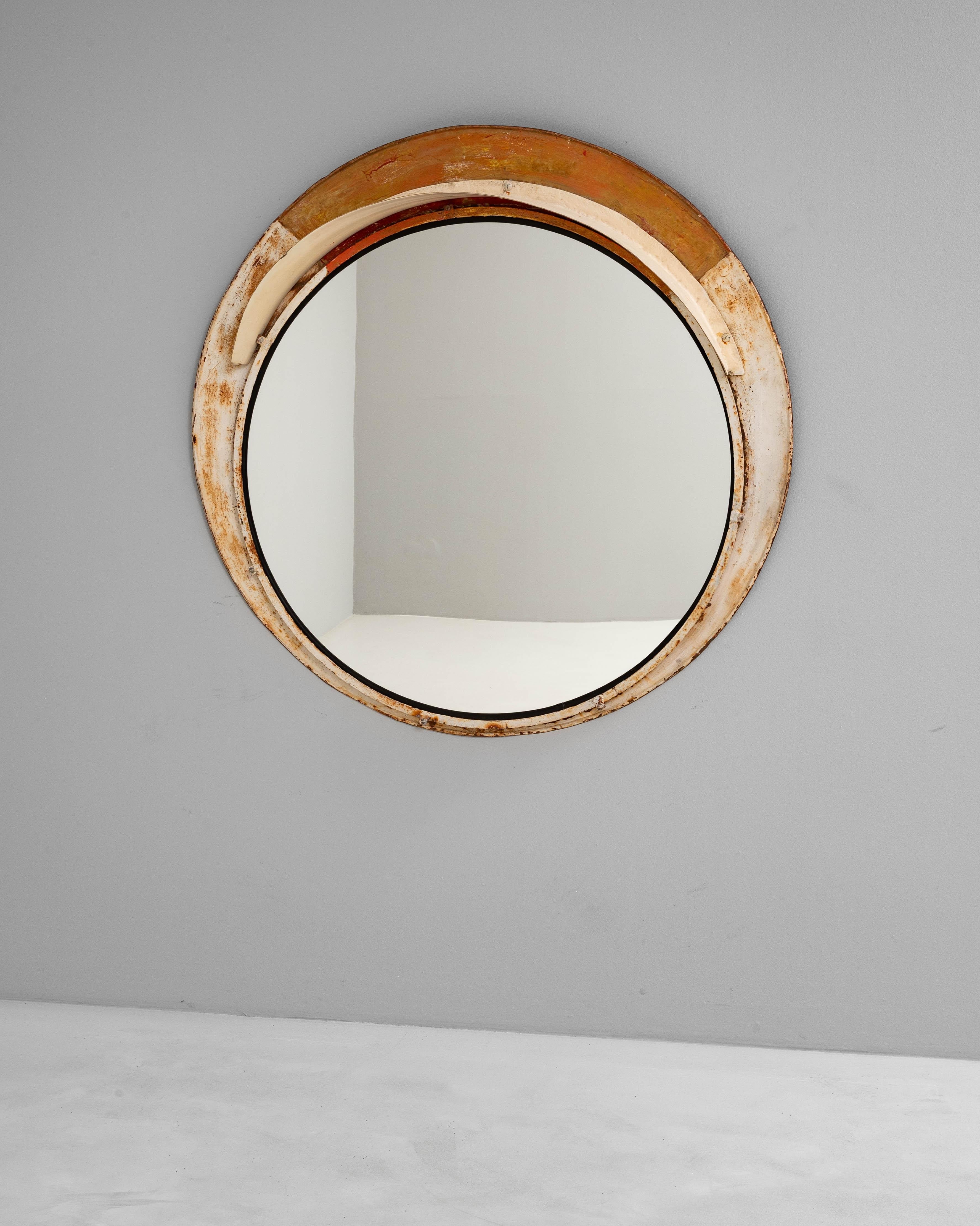 Ce miroir rond en métal tchèque du 20e siècle présente une esthétique industrielle frappante associée à une simplicité intemporelle. Doté d'un robuste cadre circulaire en métal patiné par les intempéries, il reflète à la fois la durabilité et le