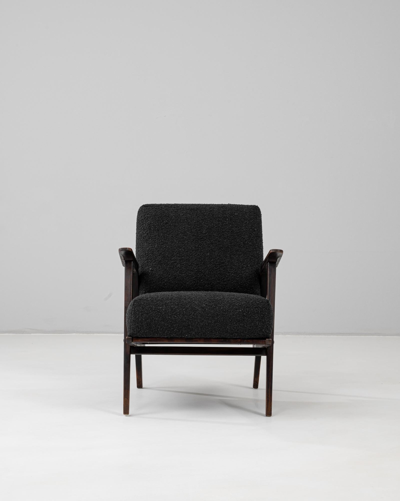 Fauteuil tapissé tchèque du 20e siècle présentant les lignes épurées et la précision géométrique caractéristiques du design moderne du milieu du siècle. La structure en bois massif, finie dans une teinte foncée, présente des pieds et des accoudoirs