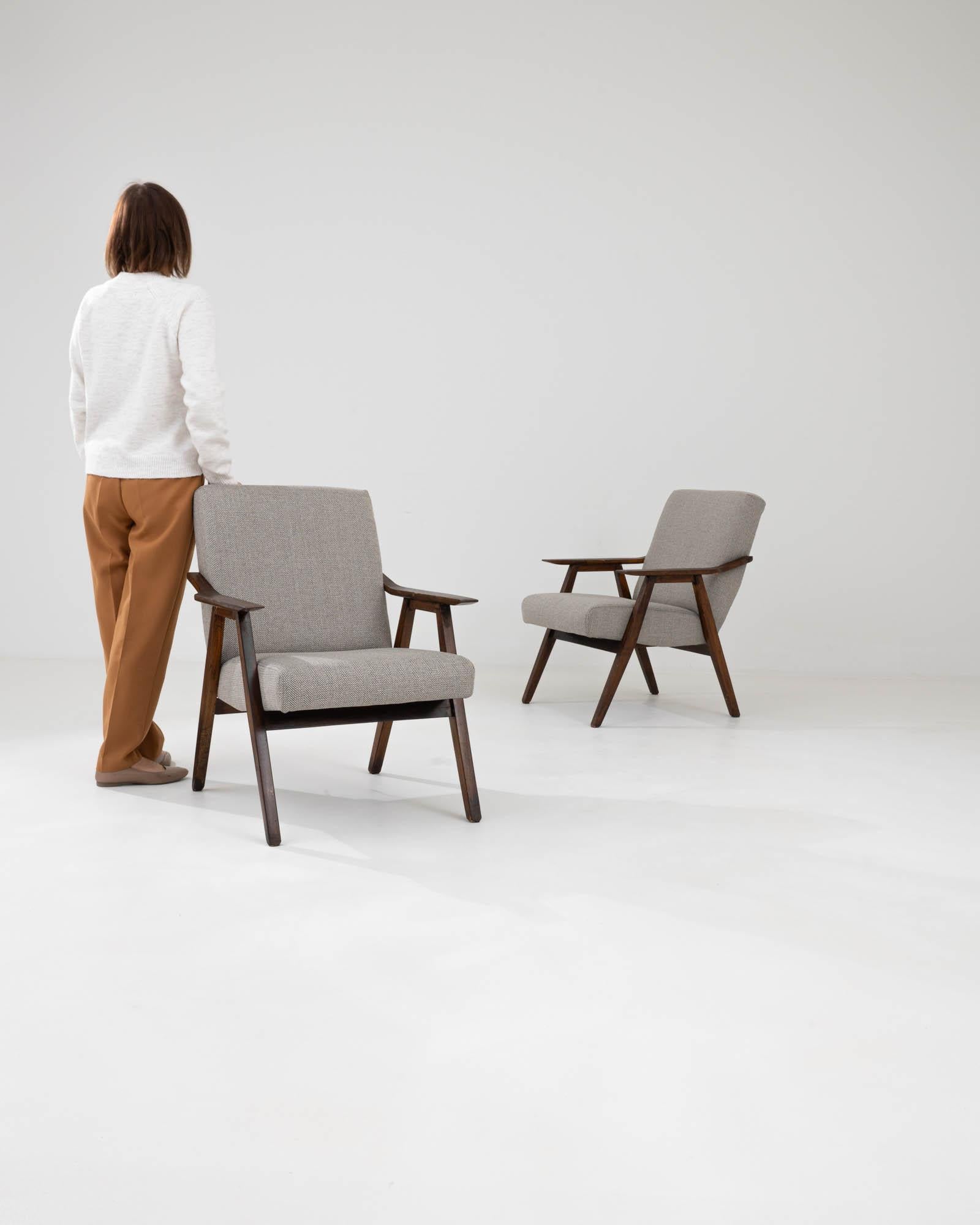 Rehaussez votre intérieur avec le charme raffiné de cette paire de fauteuils tapissés tchèques du 20e siècle. Ces chaises présentent un mélange frappant d'éléments de design classiques et contemporains, avec des cadres en bois robustes et un