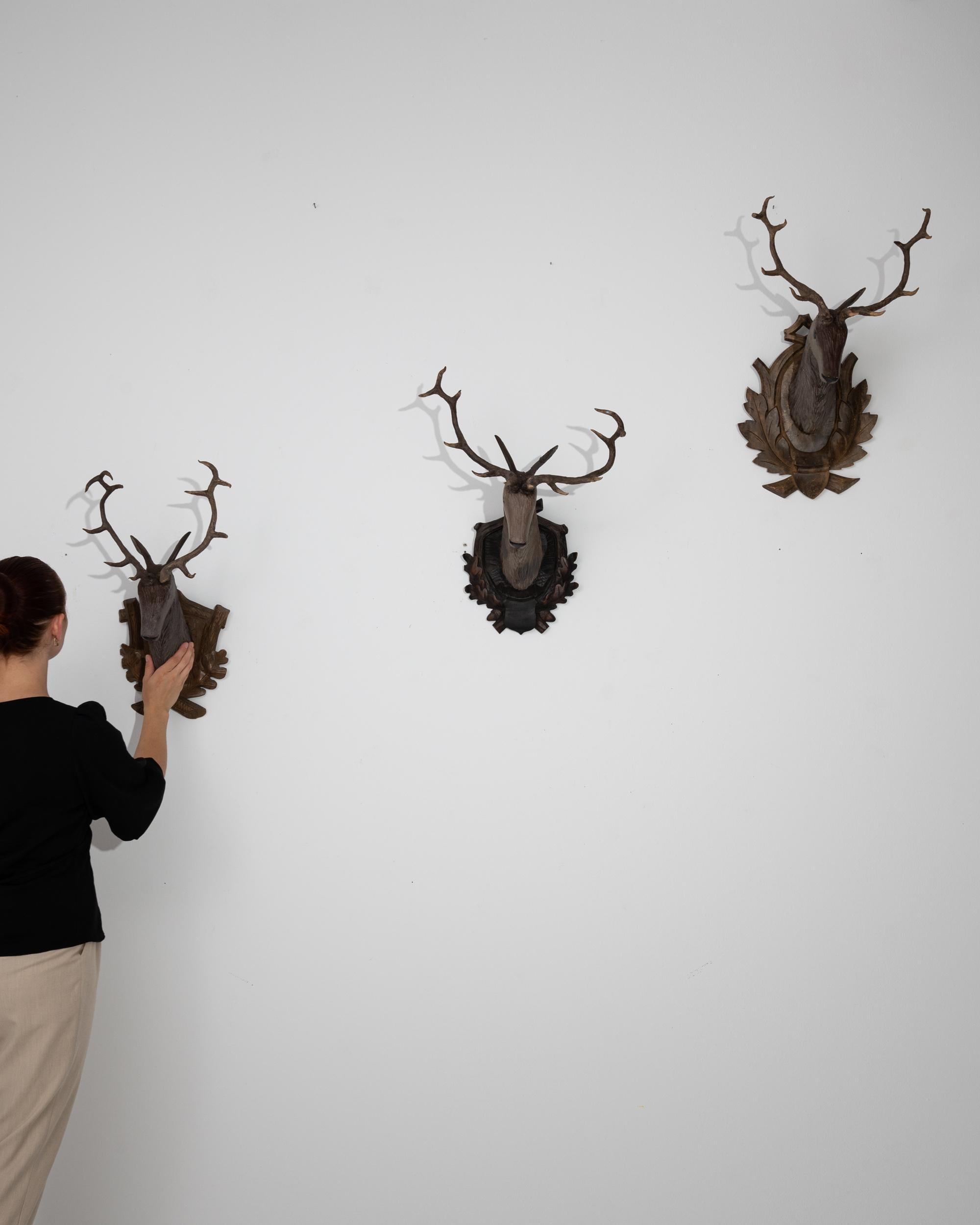 This set of three 20th Century Czech wooden deer decorations encapsulates the rustic beauty of nature's wild fauna. Each piece is meticulously carved with an attention to detail that brings the essence of the forest into your home. The rich, dark