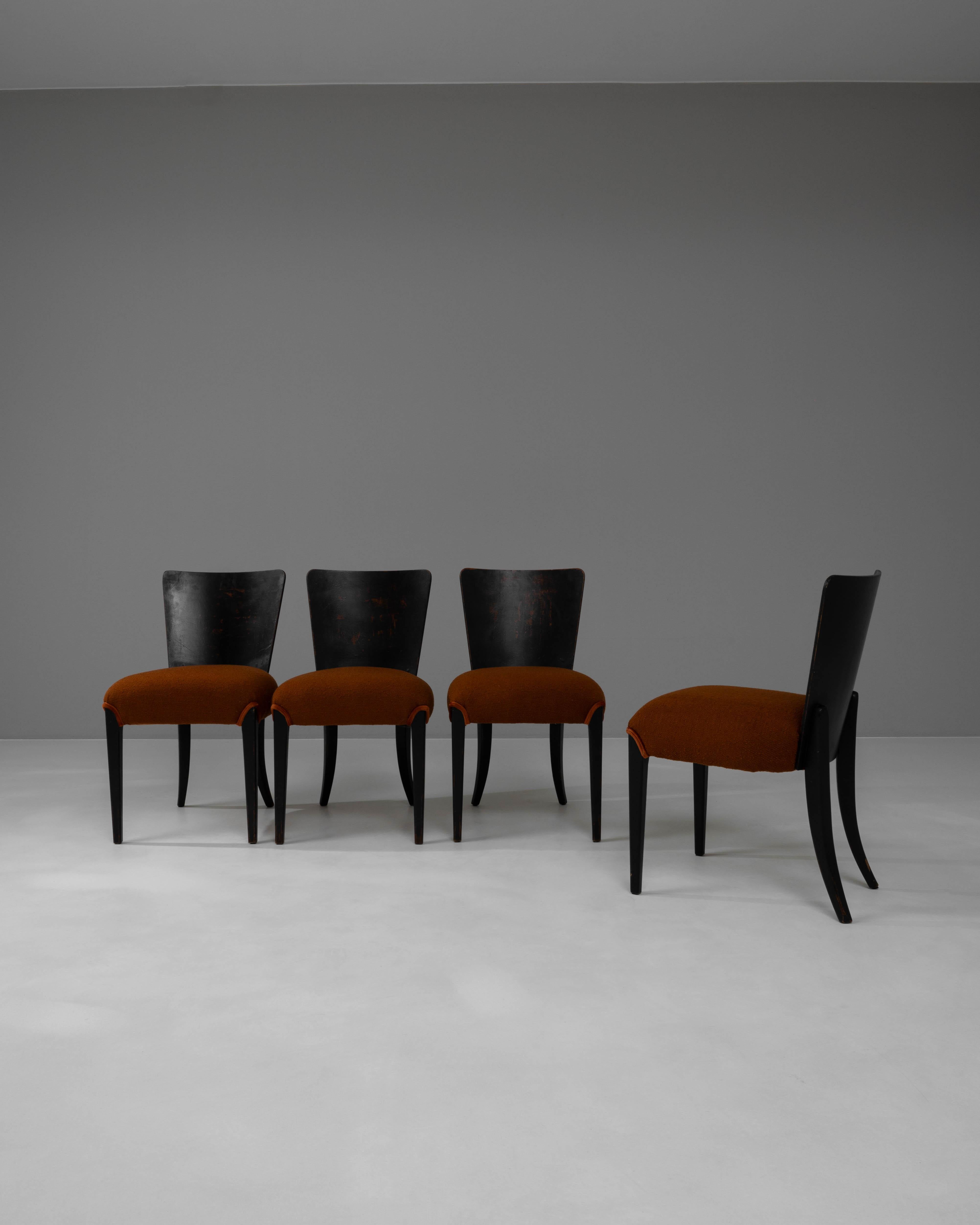 Elevate your dining room with this set of four striking 20th Century Czech Wooden Dining Chairs, masterfully designed by J. Halabala. Known for his innovative approach to design, Halabala's chairs feature sleek, curvaceous backrests that meld