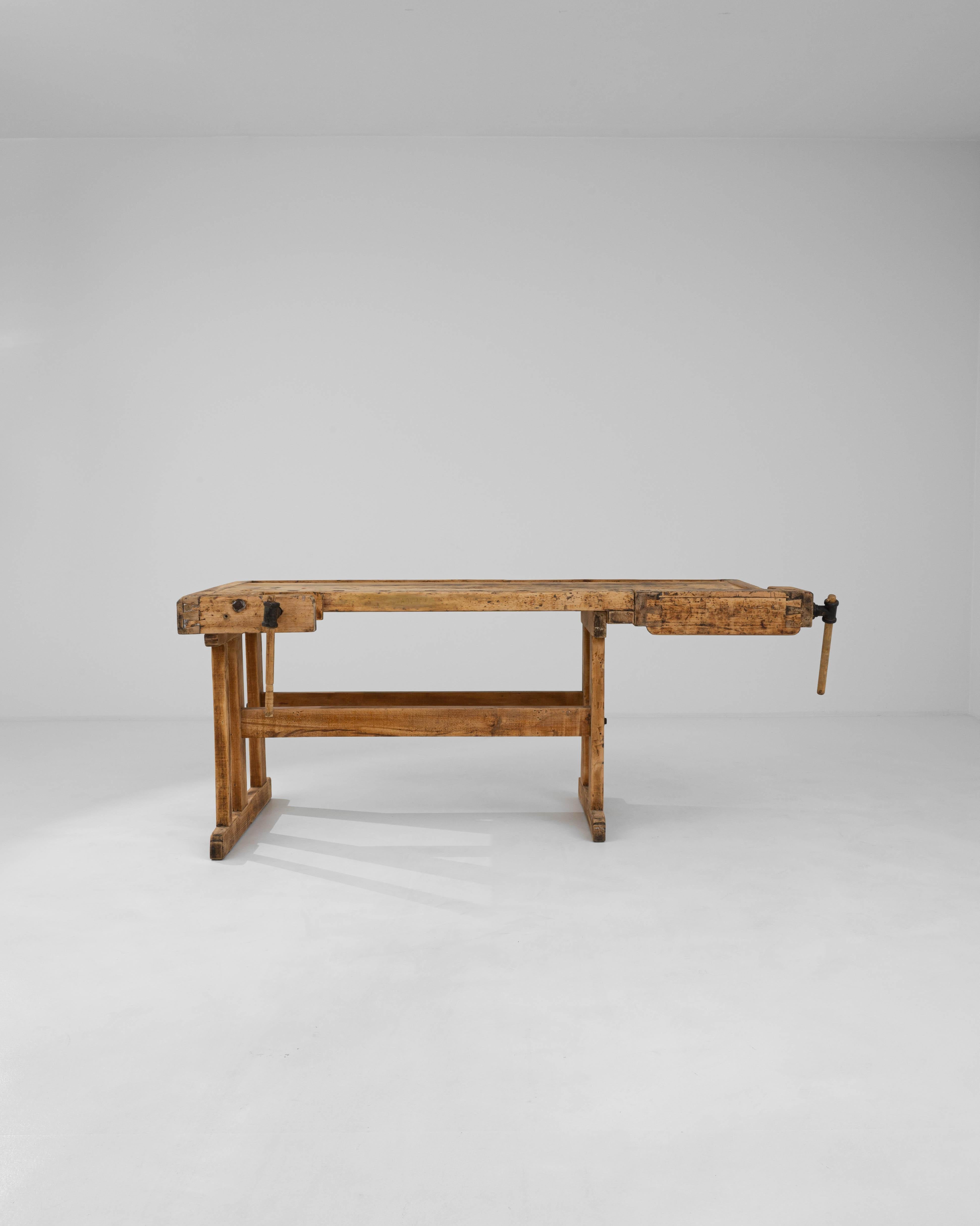 With its workmanlike design and warm natural finish, this vintage wooden table makes a striking Industrial accent. Built in Czechia in the 20th century, this piece would have originally been used as a carpenter’s work bench; the impressive iron