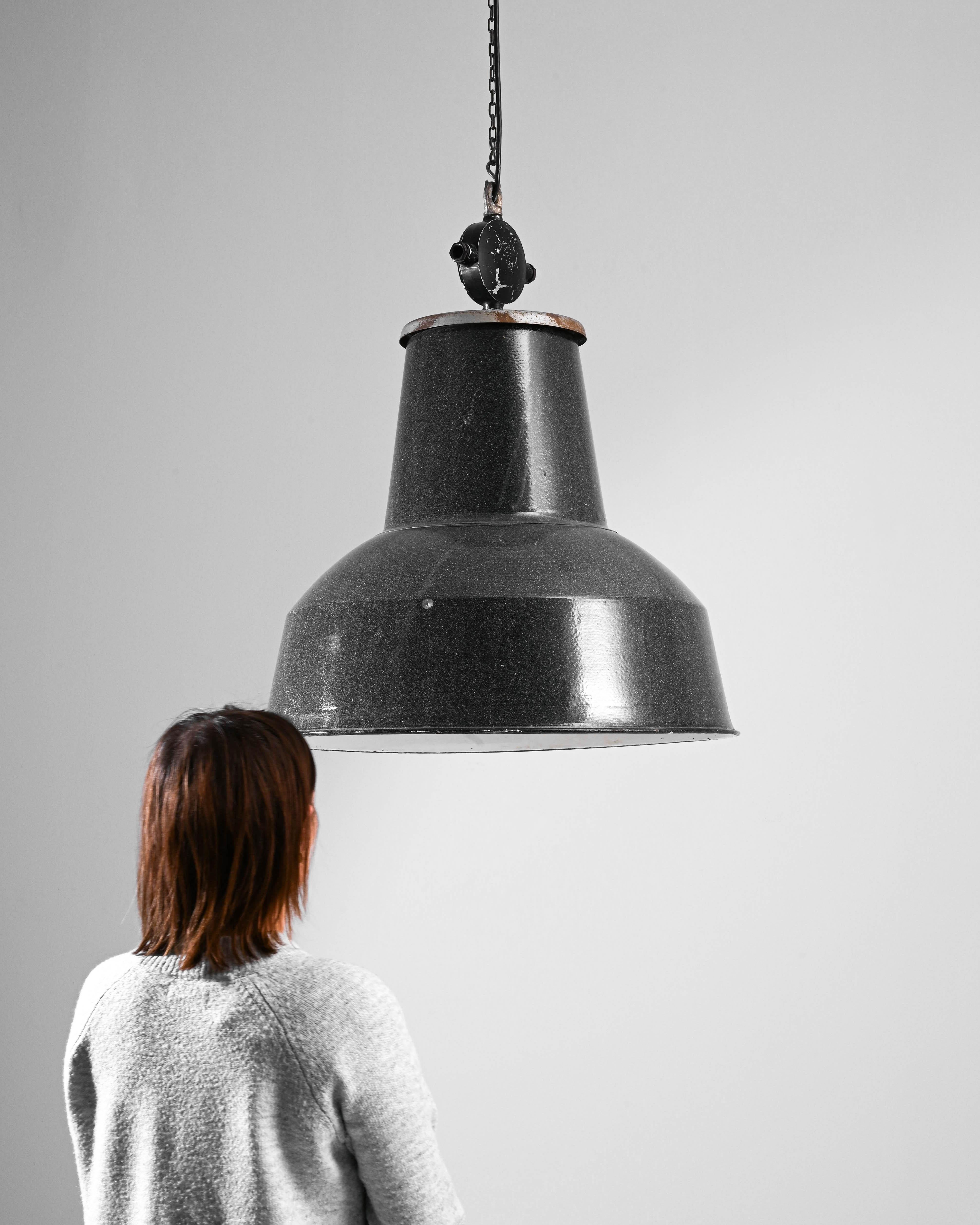 Illuminate your space with a touch of industrial history – the 20th Century Czech Industrial Pendant Lamp. This robust lighting fixture embodies the raw aesthetic of its era, featuring a substantial metal shade whose time-weathered patina tells a