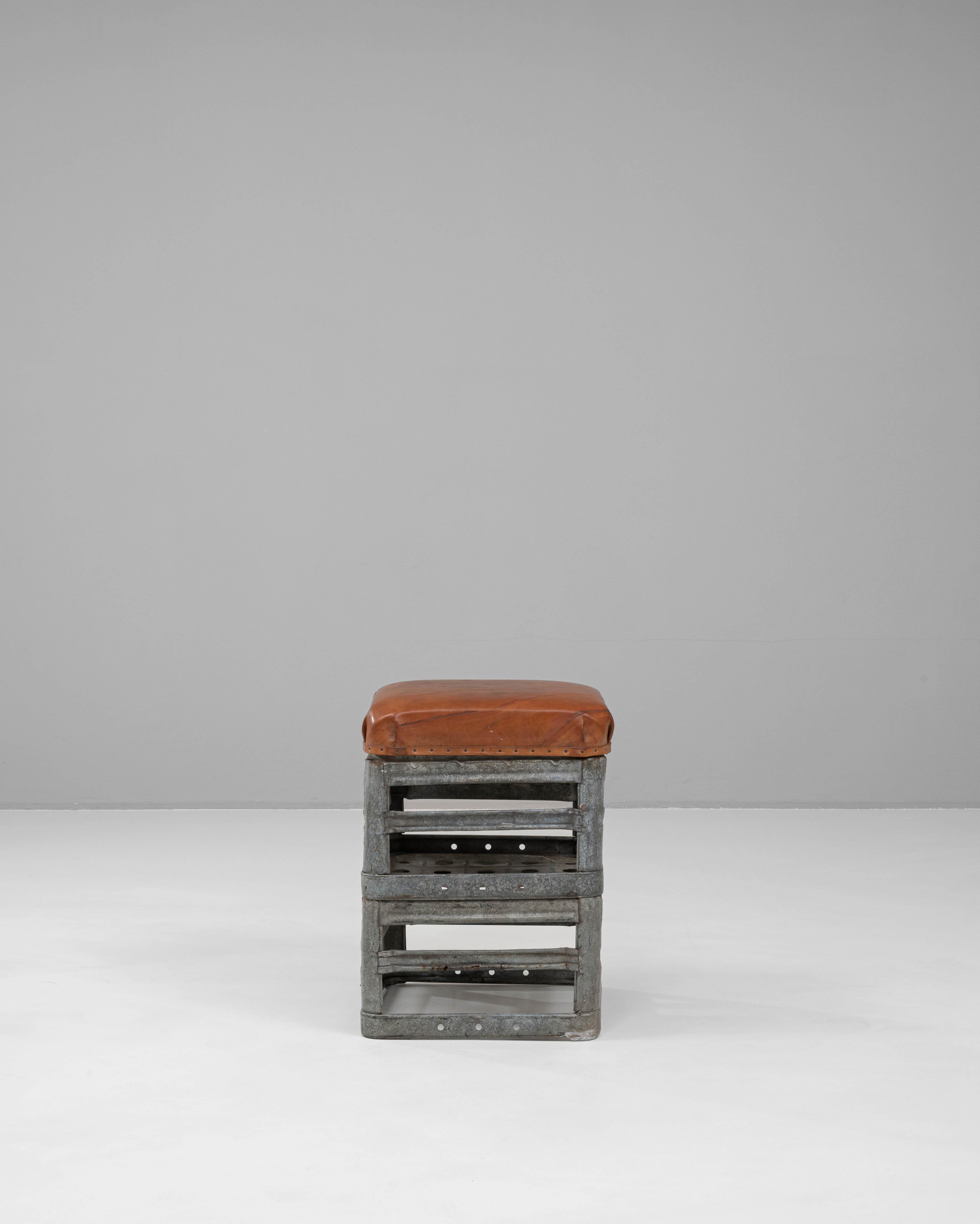 Ce tabouret en métal tchèque du XXe siècle allie le caractère industriel au confort chaleureux et tactile. Le cadre robuste, construit en acier galvanisé, présente un design géométrique ouvert avec des rivets visibles qui mettent en valeur
