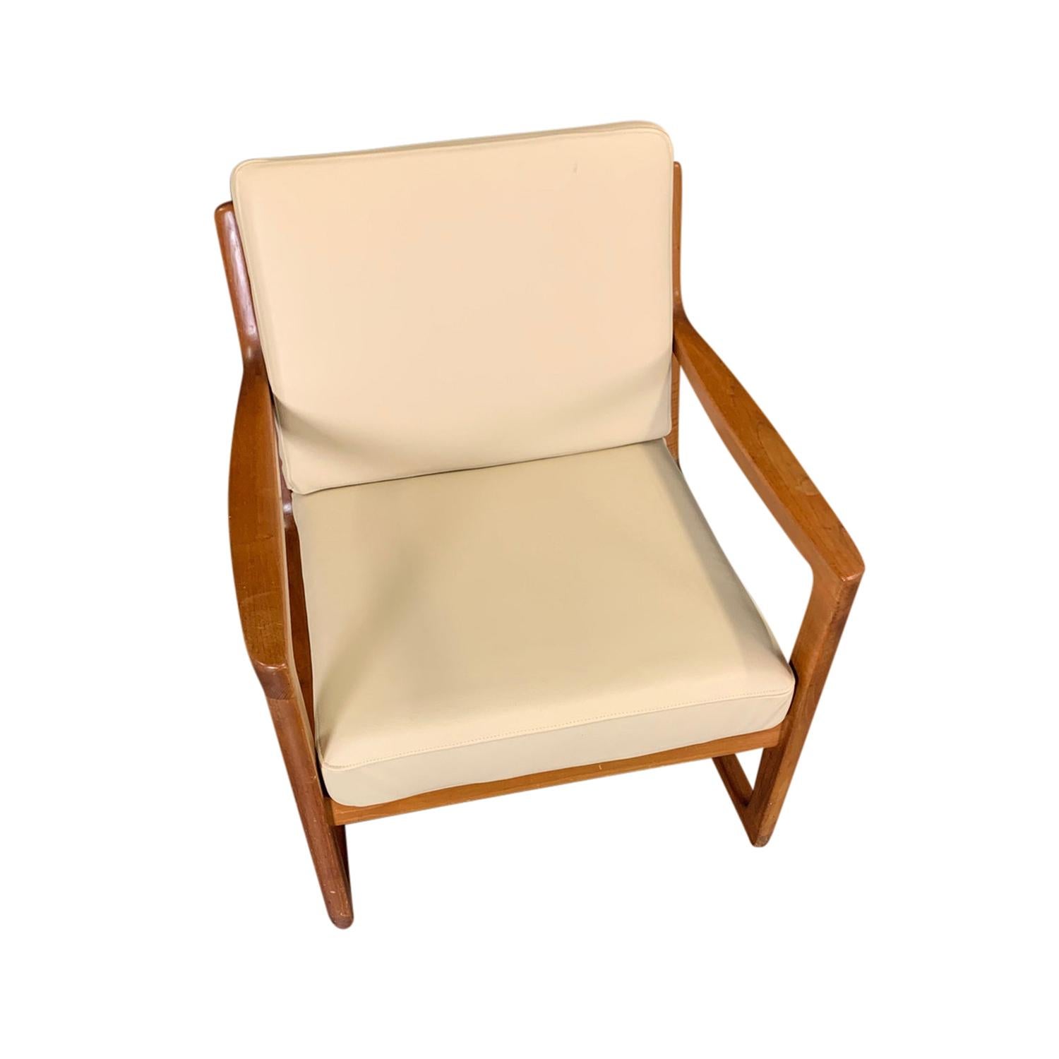 A light-brown, vintage Mid-Century Modern Danish Schaukelstuhl, rocking chair made of hand carved Teakwood, designed by Ole Wanscher and produced by France & Søn, in good condition. The back rest of the Scandinavian side, end chair is open with
