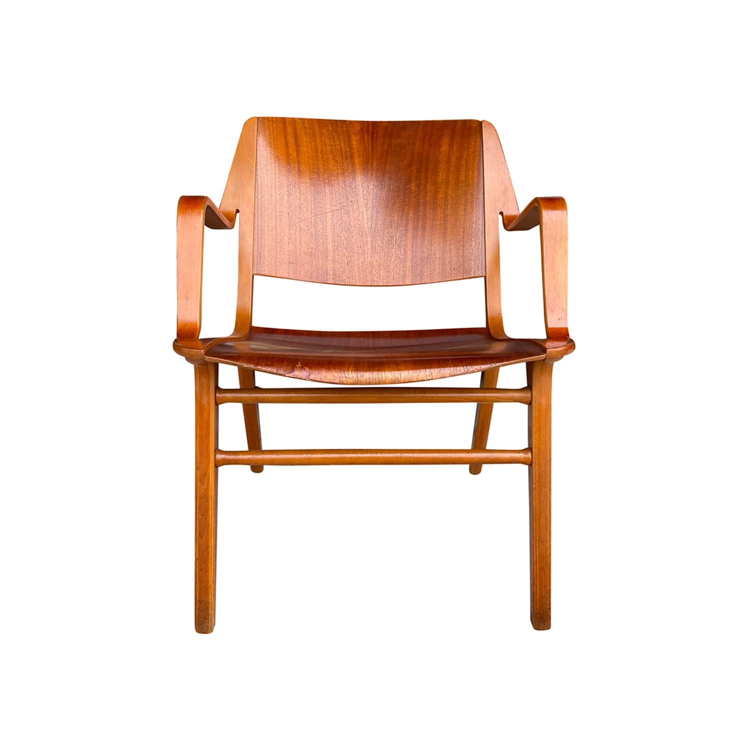 A light-brown, vintage Mid-Century Modern Danish wooden side armchair, designed by Peter Hvidt & Orla Mølgaard - Nielsen and produced by Fritz Hansen. The chair is formed with laminated Beechwood, the seat is made of hand carved Teakwood and