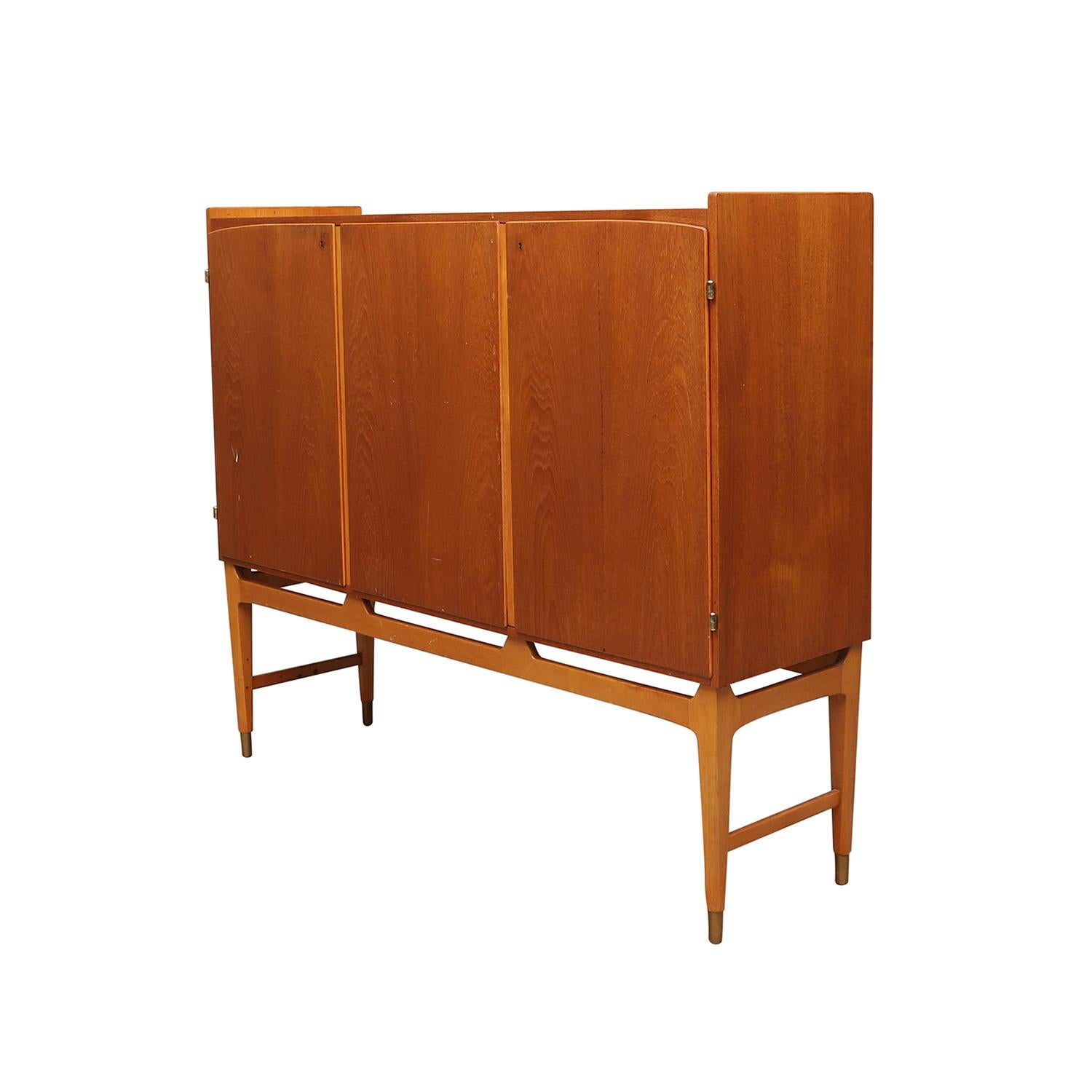 Un mobile danese vintage di metà secolo in legno di teak lucidato e parzialmente impiallacciato, disegnato da Kirke Nielsen e prodotto da Abrahamssons Möbelfabrik AB, in buone condizioni. La credenza rettangolare bassa è composta da tre grandi ante,