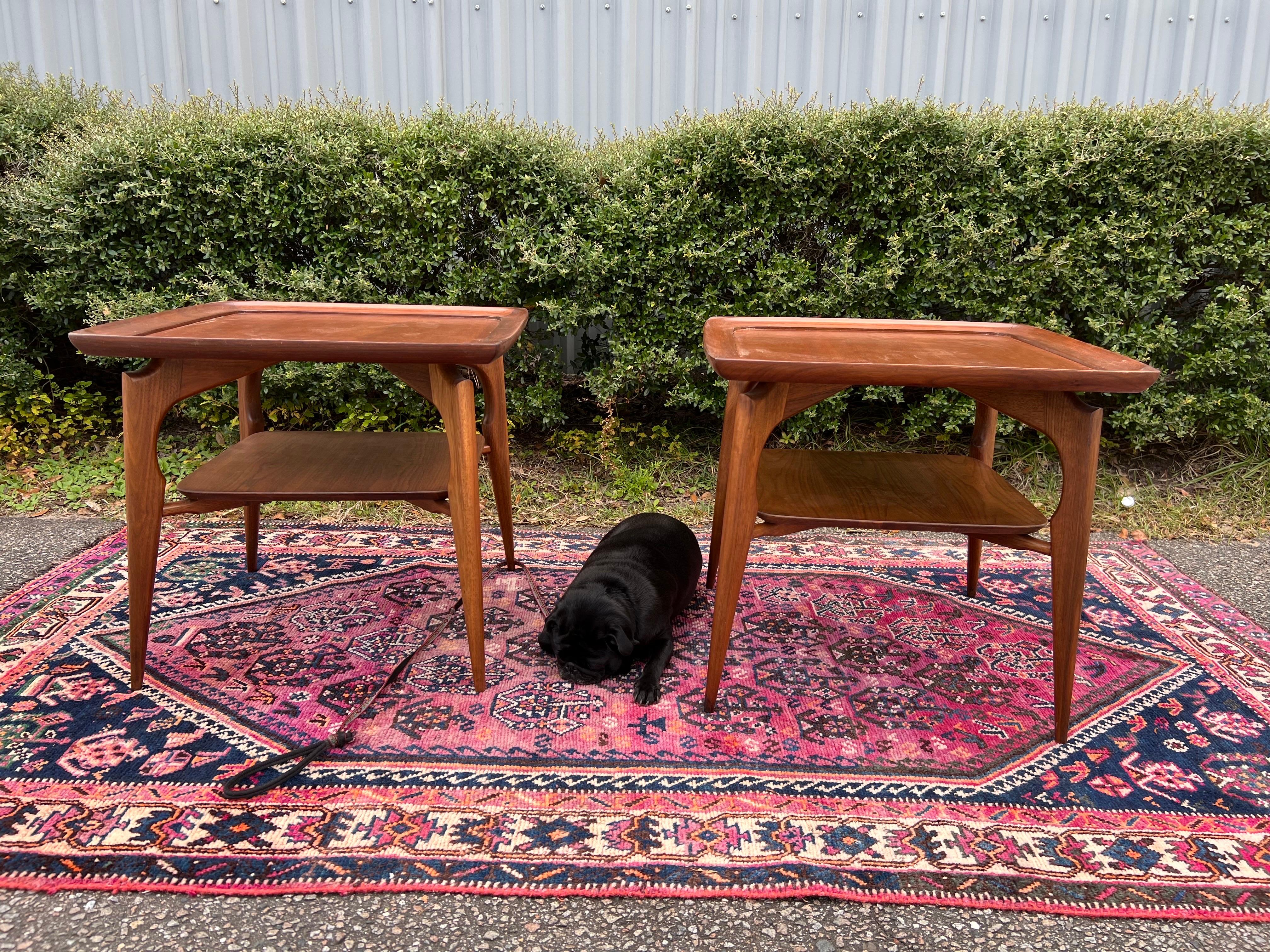 Pair of Mid Century Danish Modern Walnut Sculptural End Tables. These gorgeous tables feature a deep lipped round edging along the table top, lower shelves, raised and sculpted edges. Solid walnut frames, tapered legs, and sleek sculptural form,