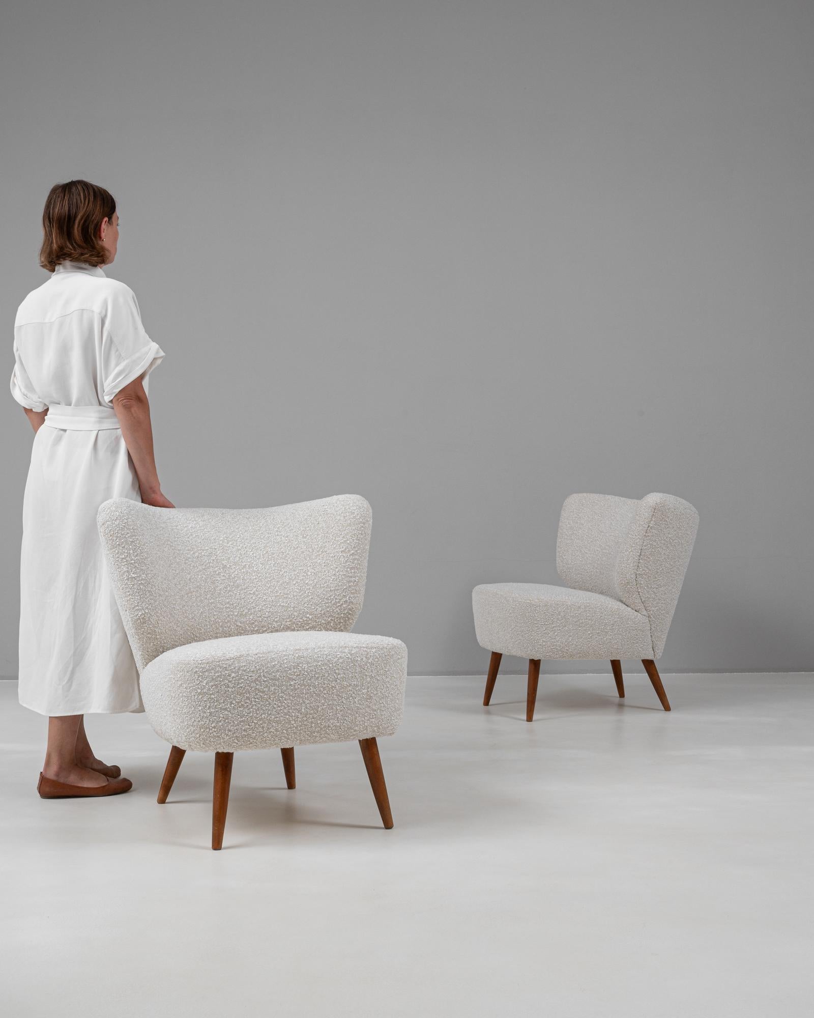 Questa affascinante coppia di poltrone danesi del XX secolo emana una raffinatezza di metà secolo grazie alle sue curve eleganti e al suo design raffinato. Rivestite in un tessuto morbido e strutturato, queste sedie offrono un'atmosfera accogliente