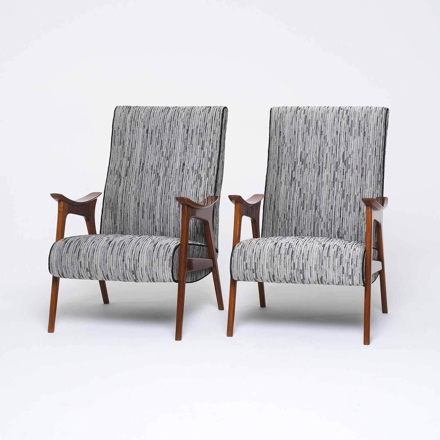 A grey Mid-Century Modern Danish pair of Scandinavian lounge chairs featuring slightly curved armrests and a large backrest, in good condition. This vintage pair has been completely restored in a Teakwood polish and reupholstered in a Pierre Frey