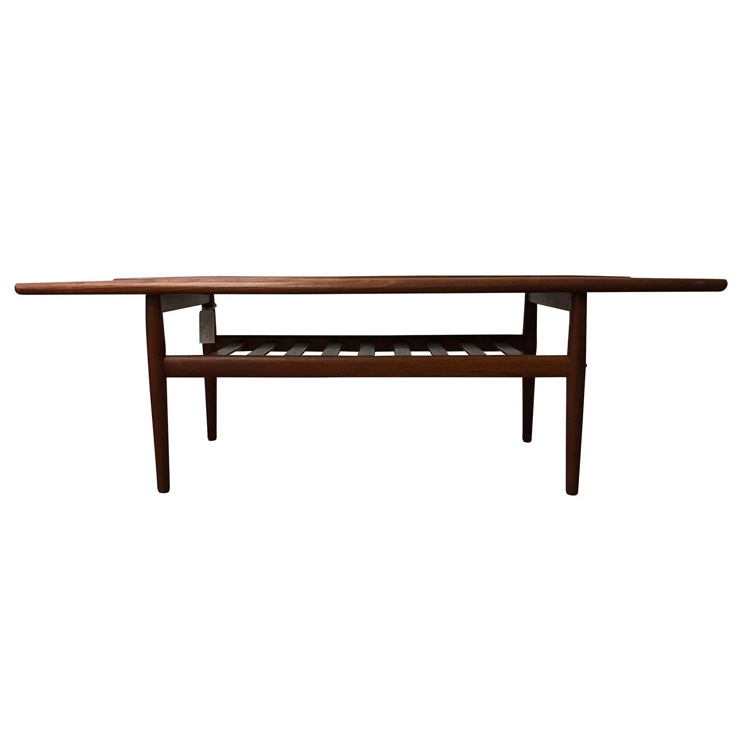 A brown, vintage Mid-Century Modern Danish coffee, sofa table made of hand crafted Teakwood, designed by Hans J. Wegner and produced by Andreas Tuck in good condition. Wear consistent with age and use. Circa 1960 Denmark, Scandinavia.

Hans