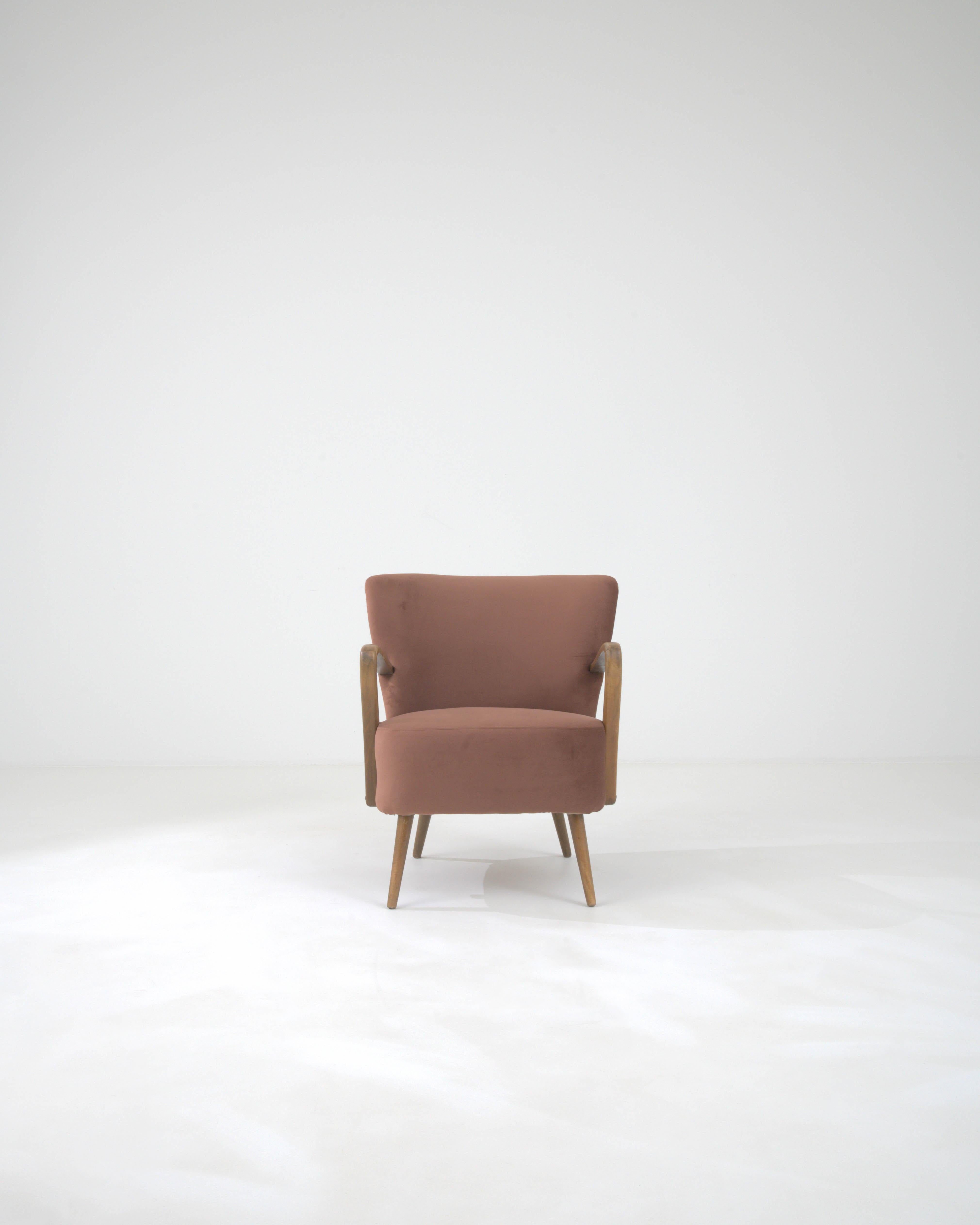 Introducing the 20th Century Danish Upholstered Armchair, a fusion of minimalist design and comfort that brings a touch of Scandinavian sophistication to any room. This mid-century modern gem features a sleek, organic wooden frame complemented by a