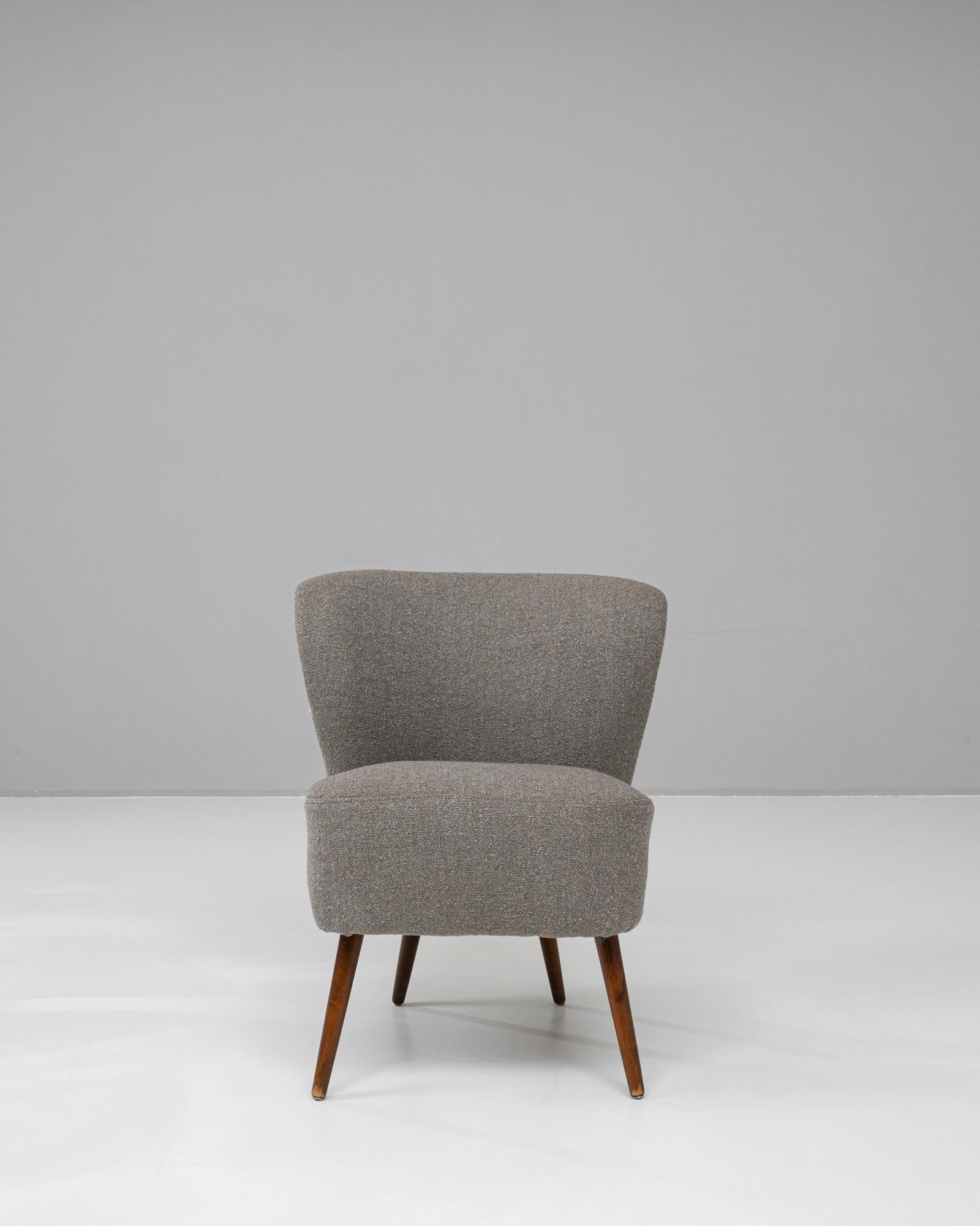 Questa sedia imbottita danese del XX secolo emana un'eleganza senza tempo che combina stile e comfort senza sforzo. Lo schienale dolcemente curvo e l'imbottitura morbida della sedia offrono una seduta invitante, perfetta per qualsiasi interno