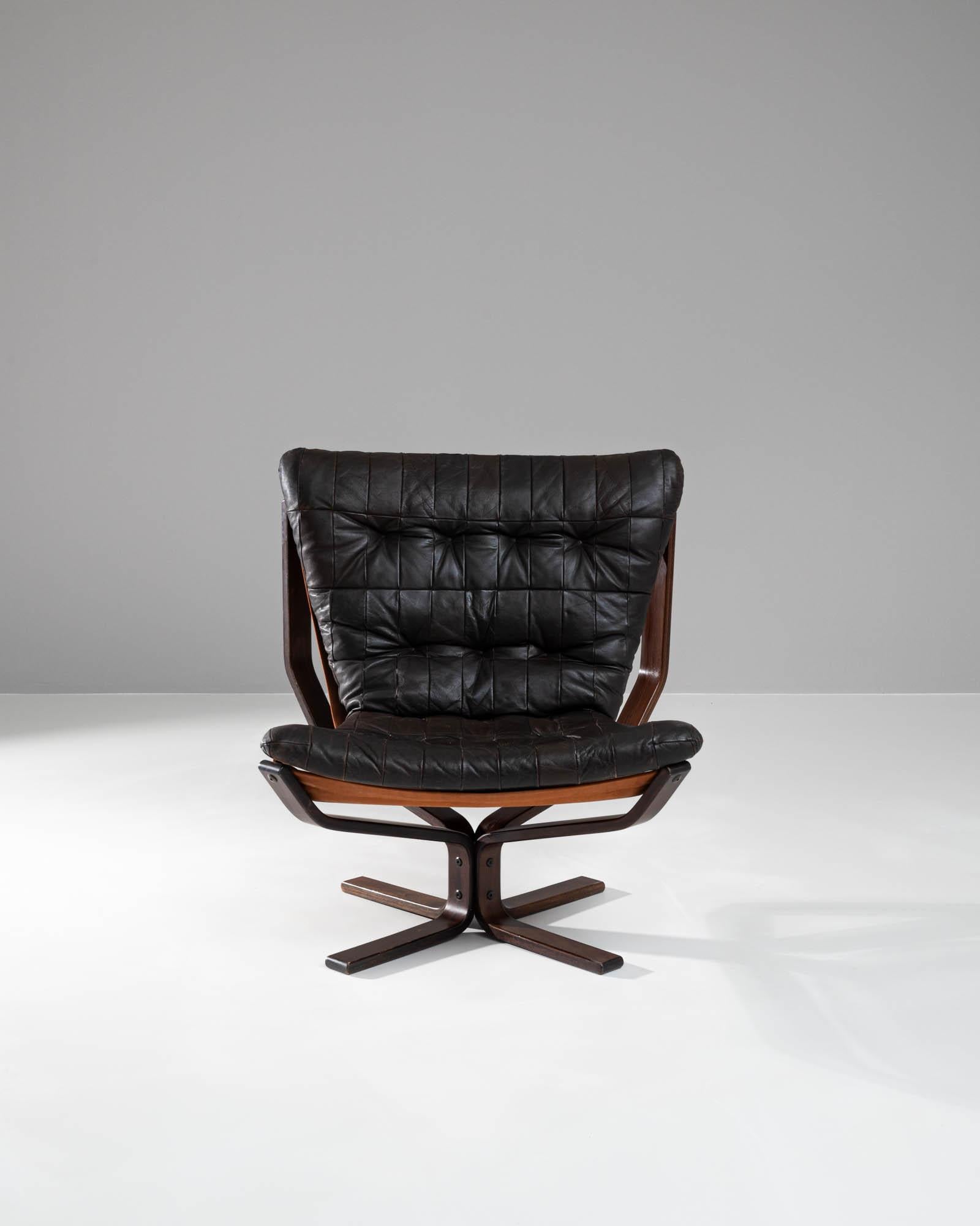 Discover a masterpiece of 20th-century design with this Danish Wooden & Leather Chair, a testament to timeless elegance and superior craftsmanship. This chair epitomizes comfort and style, featuring a sumptuously padded, tufted leather seat that
