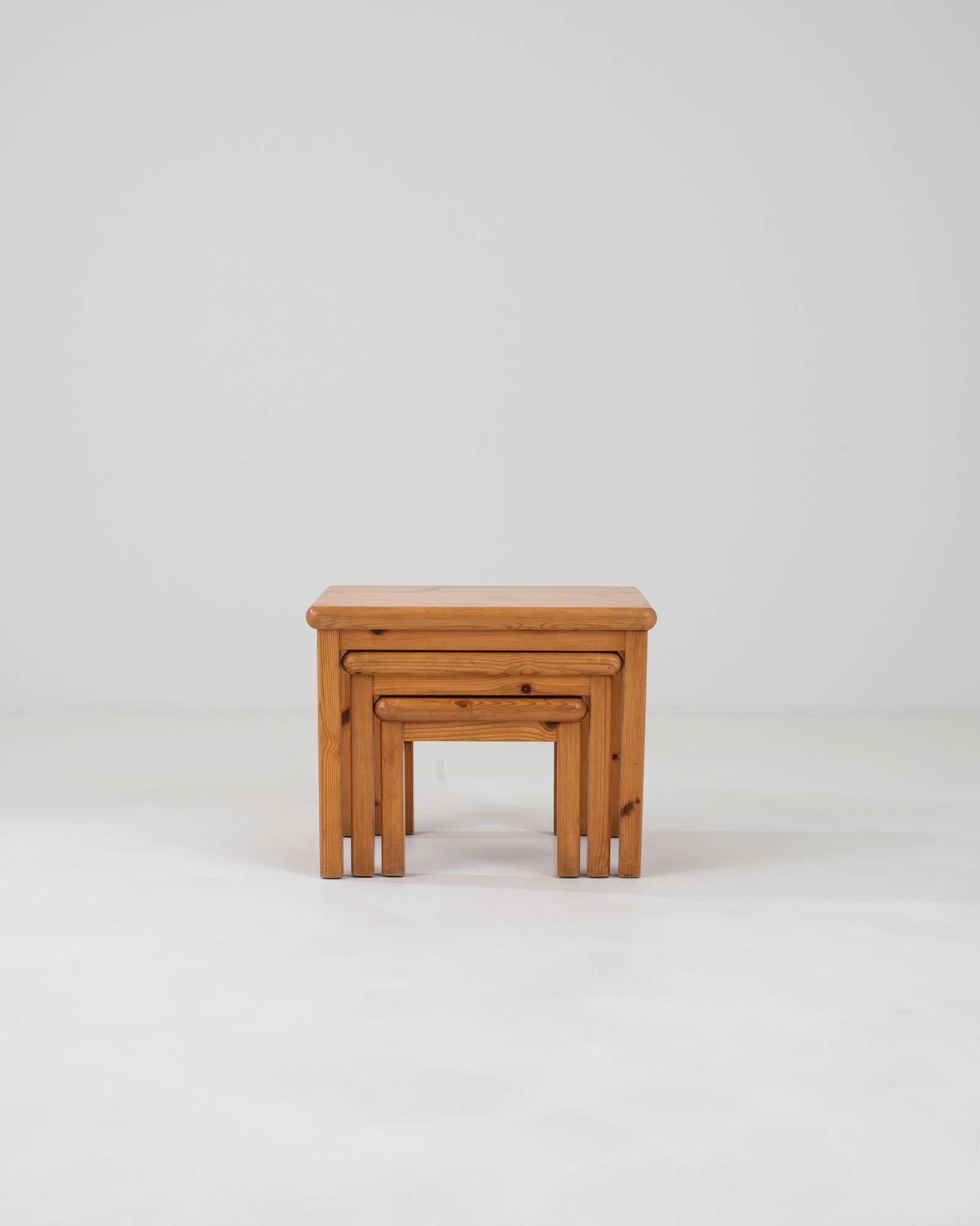 Discover the epitome of Scandinavian design with this set of three 20th Century Danish Wooden Nesting Tables. Each table is a testament to the timeless appeal of Danish minimalism, featuring clean lines and a warm, honey-toned wood finish that