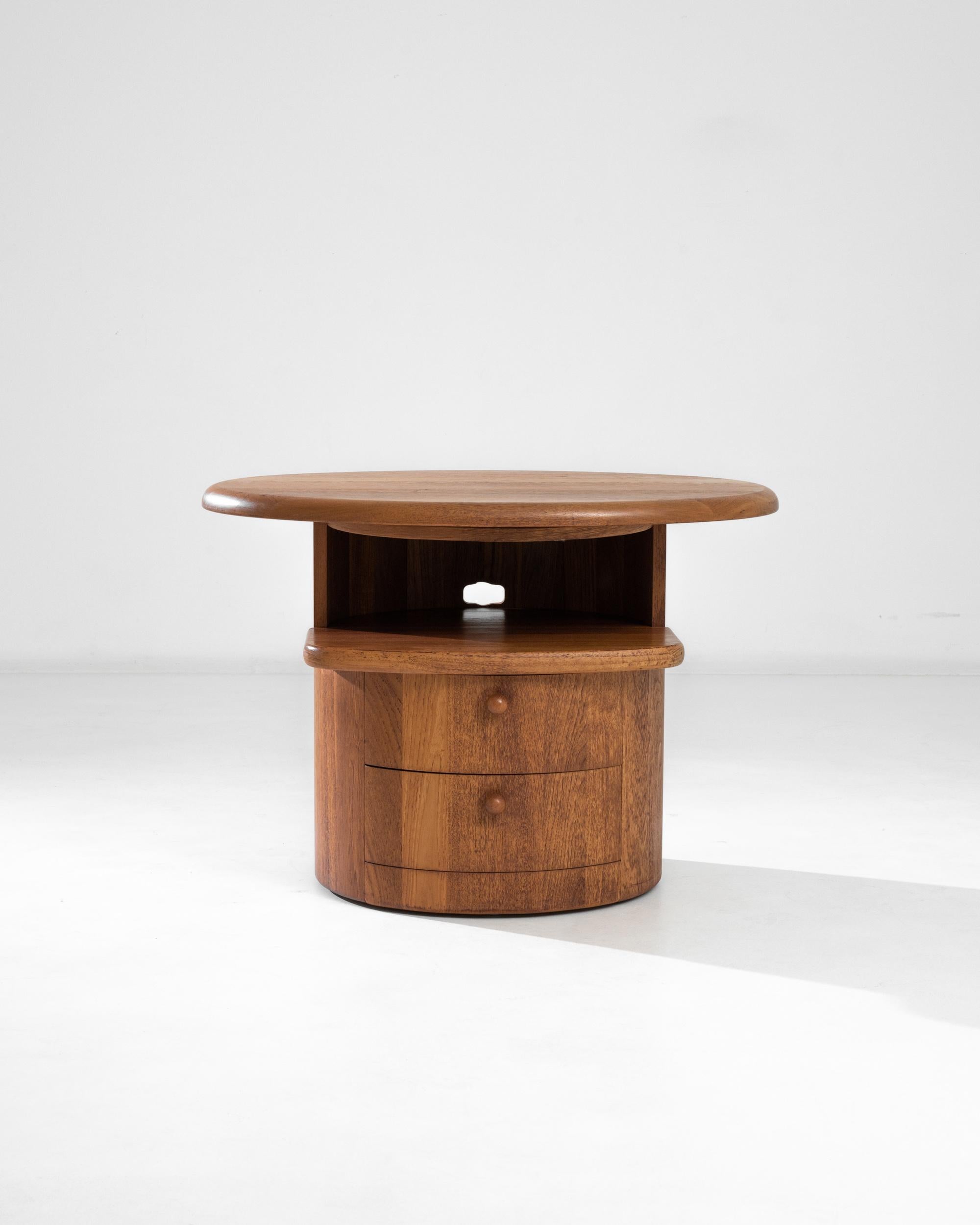 A 20th century wooden side table from Denmark, this vintage staple sports a low top under two feet, two front silent drawers and a rich smooth pecan finish with lighter caramel hues. A versatile piece with a convenient aperture for cables, perfect