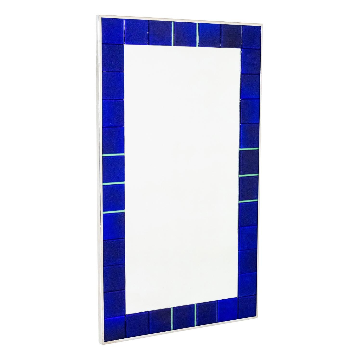 A dark-blue, vintage Mid-Century modern Italian wall mirror made of hand crafted smooth metal and cut glass with its original mirror glass, designed by Paolo Venini in good condition. The wide border of the décor piece is enhanced by detailed