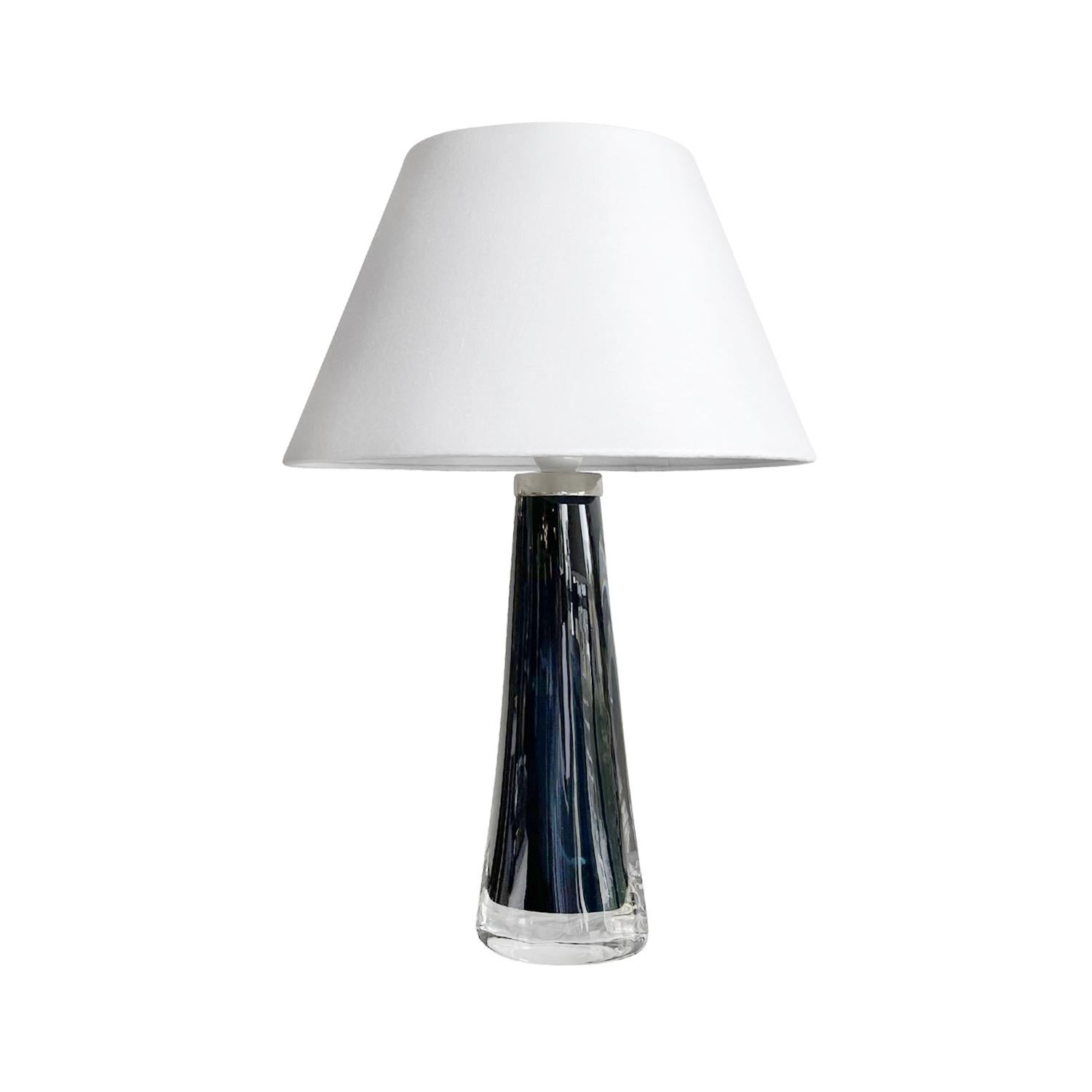 A dark-blue, black vintage Mid-Century Modern Swedish pair of table lamps with a new white round shade made of hand blown smoked Orrefors glass, designed by Carl Fagerlund and produced, signed by Orrefors in good condition. The Scandinavian desk