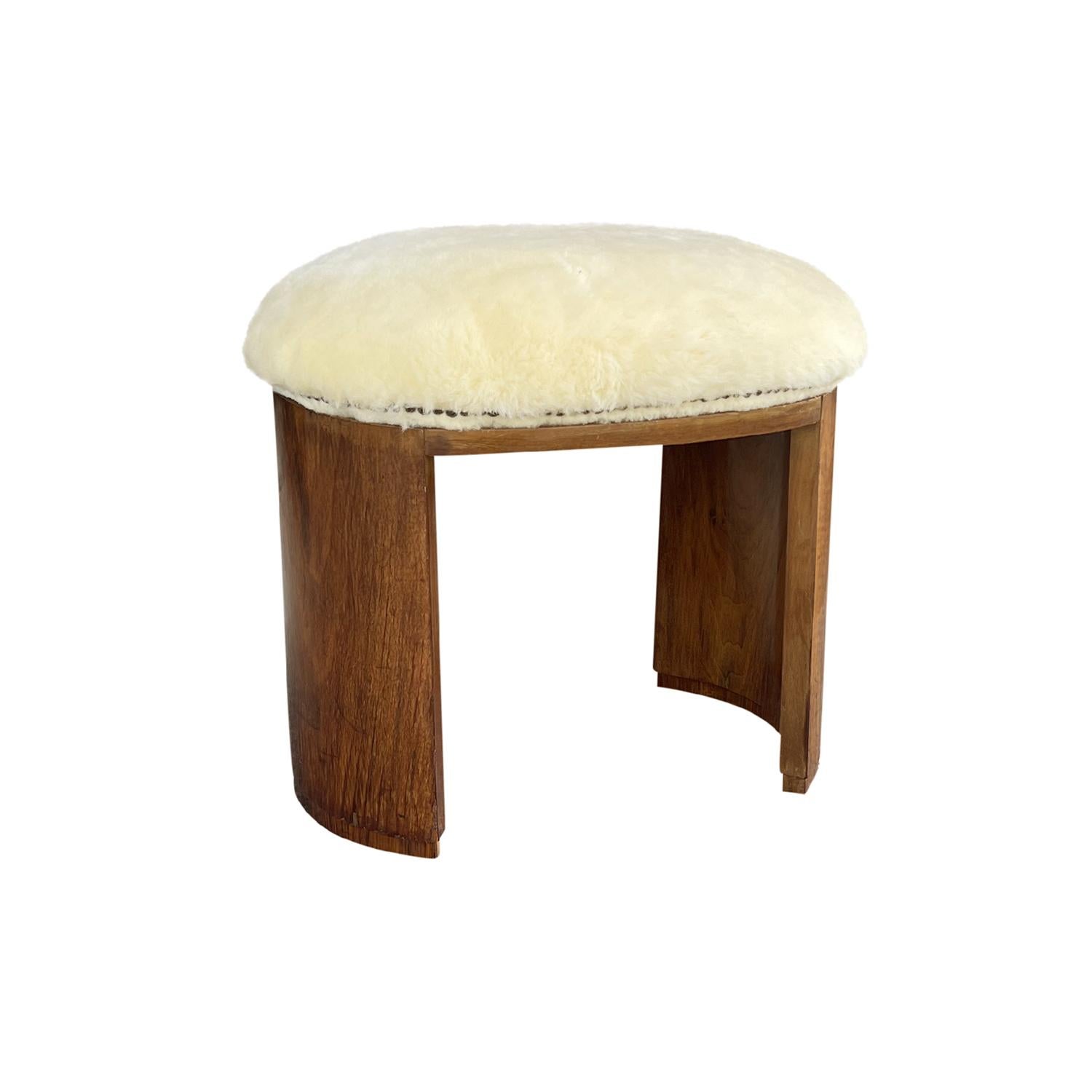 A vintage French Art Deco stool made of hand carved Cherrywood with metal nailheads, in good condition. Newly upholstered in yellow sheepskin. Minor fading due to age. Wear consistent with age and use. Circa 1925, Paris, France.