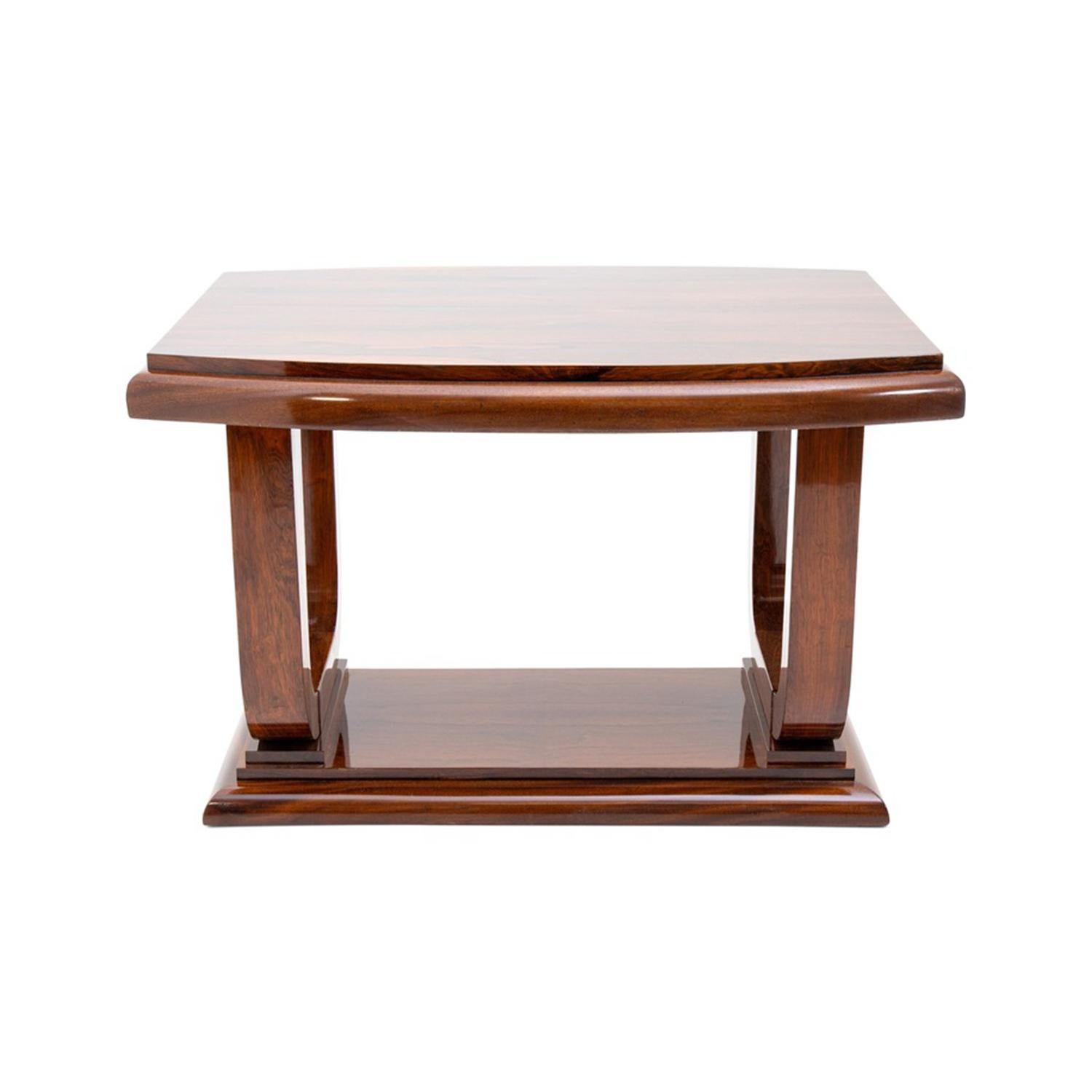 A dark-brown, vintage Art Deco French freestanding console, end table made of hand crafted polished, partly veneered Mahogany in good condition. The Parisian rectangular polished center table is supported by two wide arched legs, resting on a thick