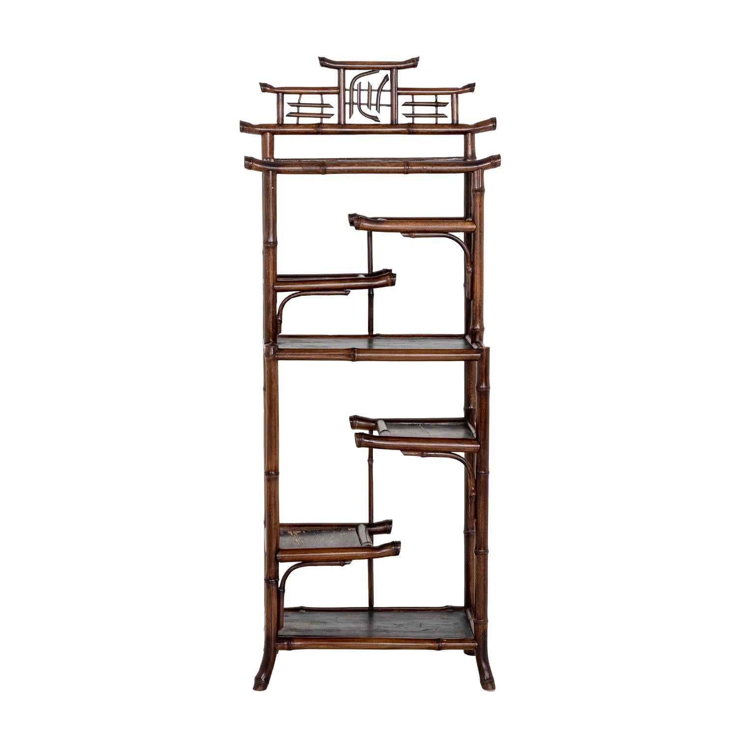 A dark-brown, vintage Mid-Century Modern French shelving made of handcrafted bamboo, in good condition. The freestanding wall rack, unit is composed with three large, small levels. The small library is particularized in the pagoda style. Wear
