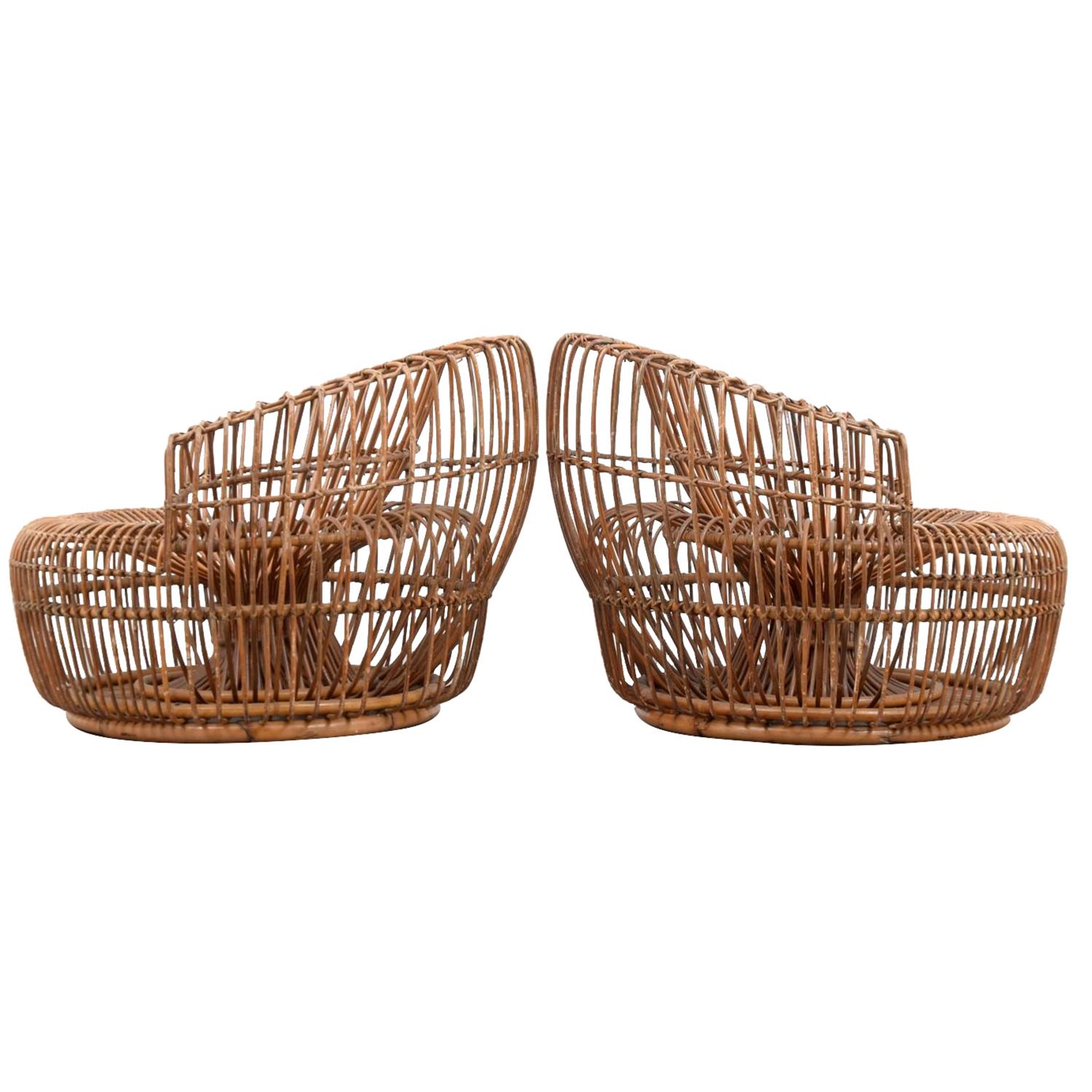 A dark-brown, vintage Mid-Century Modern Italian pair of spindled lounge chairs made of hand crafted rattan, designed by Franco Albini in good condition. The seat backrest, arms of the round corner chairs are high and curved. Wear consistent with