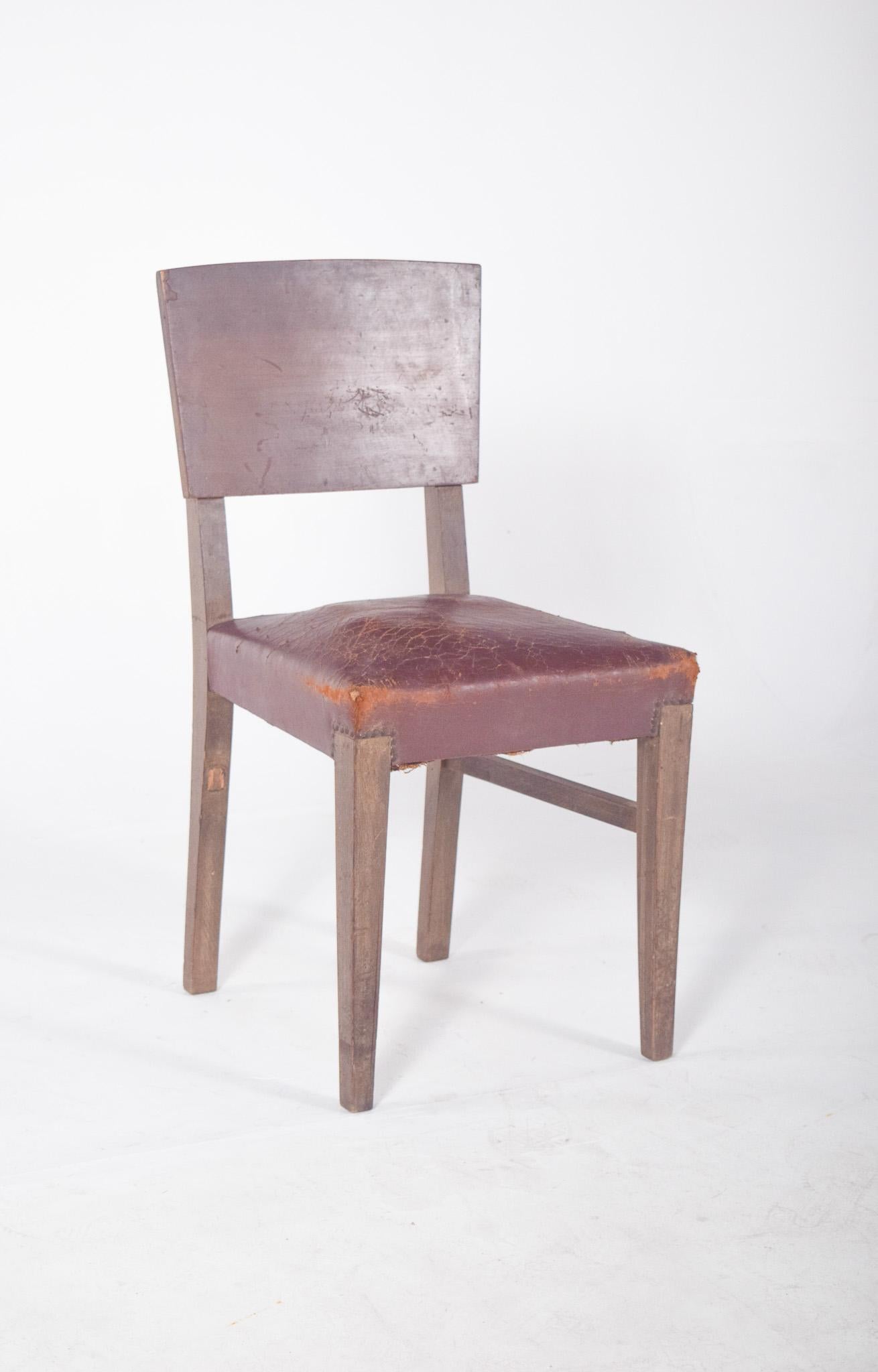 Esszimmerstuhl mit Ledersitz. Mit seinen geraden Linien und dem Massivholzrahmen repräsentiert er ein funktionales Design, das für die erste Hälfte des 20. Jahrhunderts charakteristisch ist. Die breite, leicht geschwungene Rückenlehne bietet