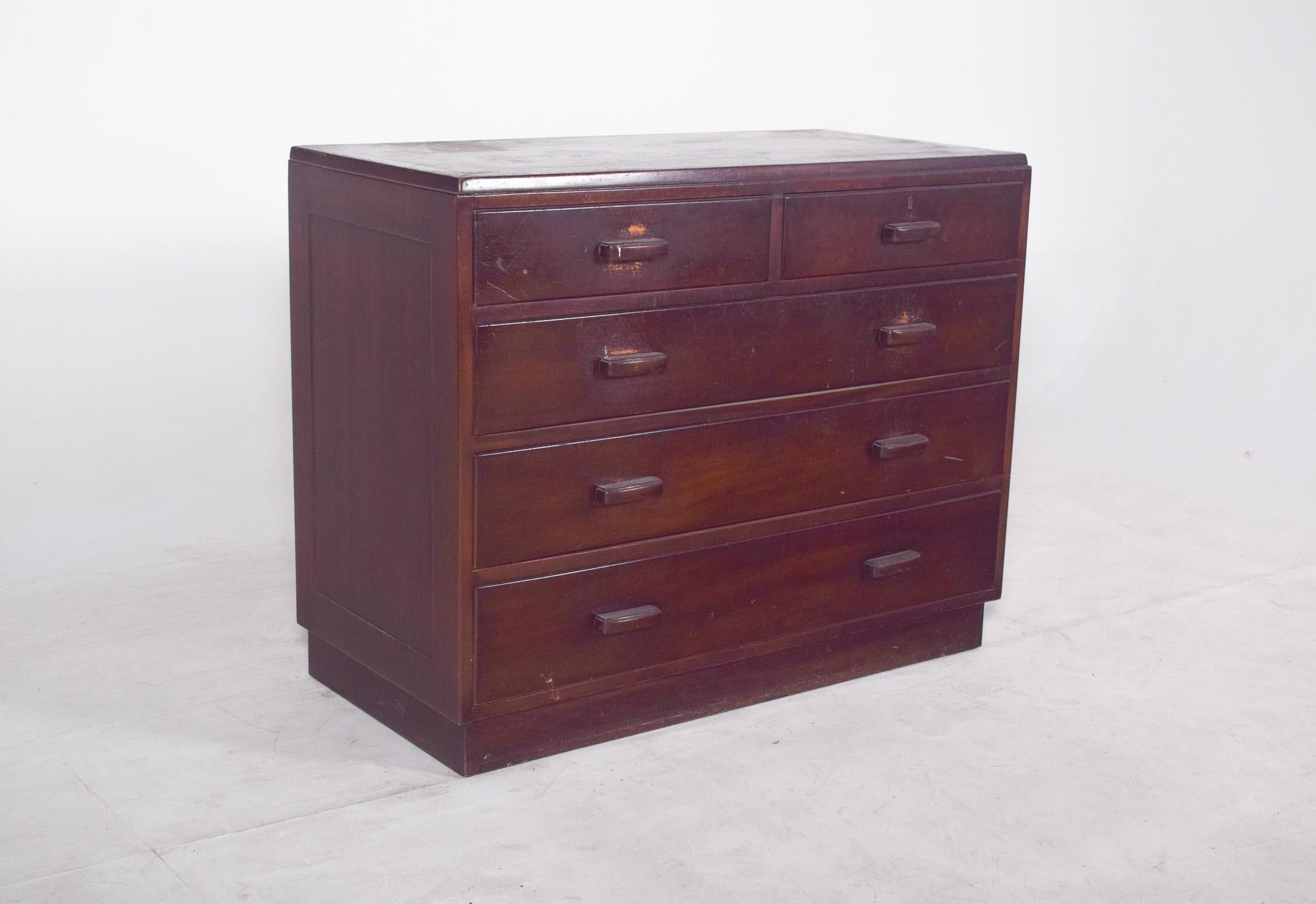 English Deco-style chest of drawers. Marked by its formal sobriety and focus on utility, this piece has five drawers distributed in two small ones at the top and three larger ones below, with horizontal wooden handles, also bevelled, which reinforce