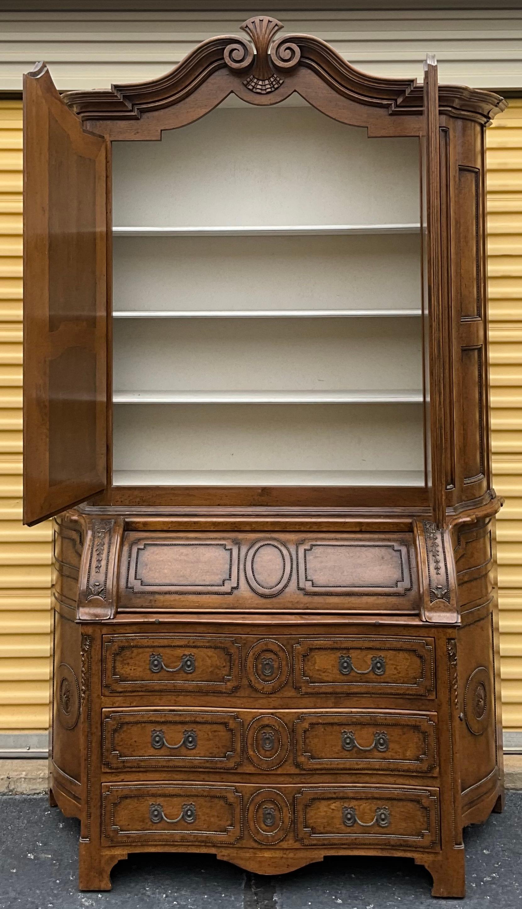 This is a show stopper! It is a large scale French style carved fruitwood Secretary by Dennis & Leen. It has an antique white painted interior as well as an incredible amount of storage. The writing surface draws out from the base and provides a
