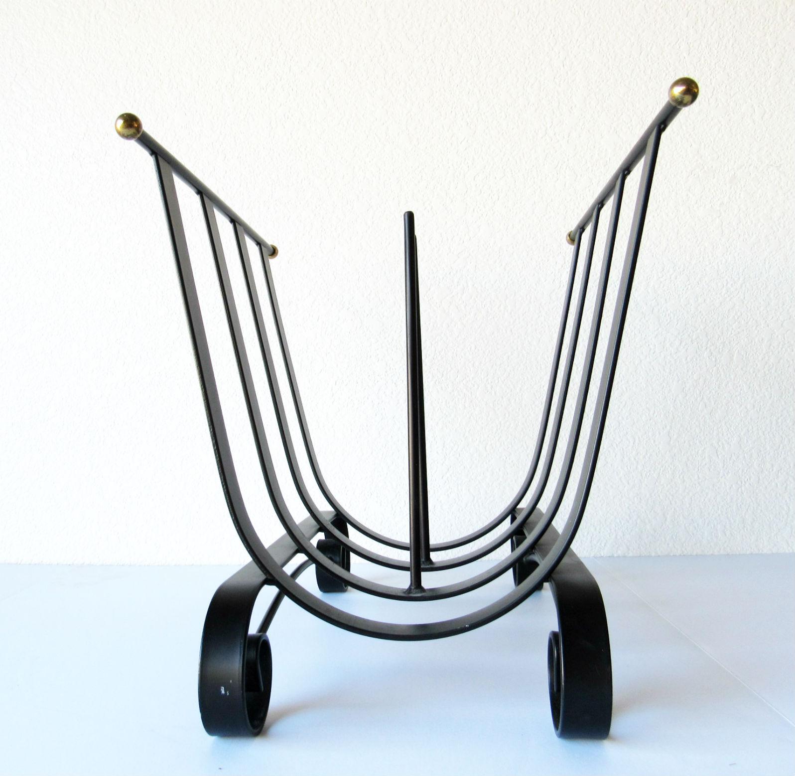 20th century design wrought iron log holder or magazine holder. Black wrought iron holder with brass ball caps, Mid-Century Modern, in very good condition.