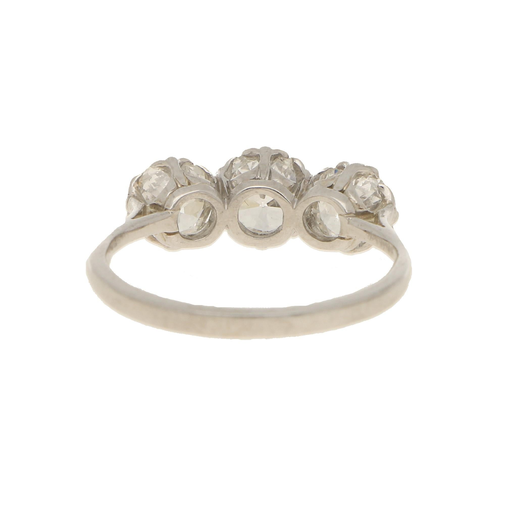A beautifully crafted early 20th century diamond three stone ring set in platinum. The central old brilliant cut diamond is estimated to weigh 0.65 carats flanked by two old round brilliant cut diamonds weighing 0.50 carats each. All diamonds are