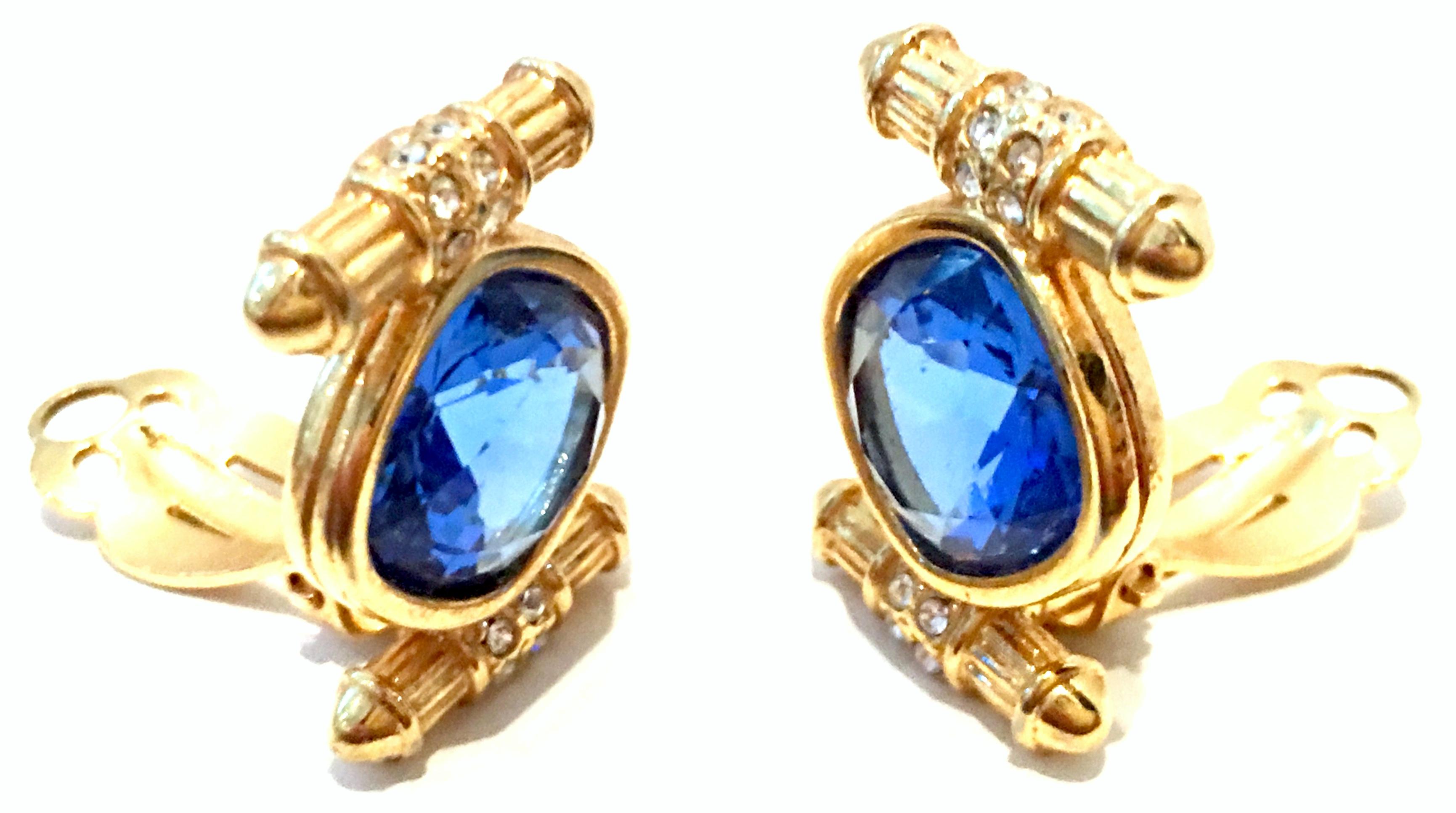 20th Century Pair Of Christian Dior Style Gold Plate & Blue Sapphire Brilliant cut and faceted Austrian crystal clip style earrings. There are round colorless cut and faceted Austrian crystal stone detail at each end of each earring. The large blue