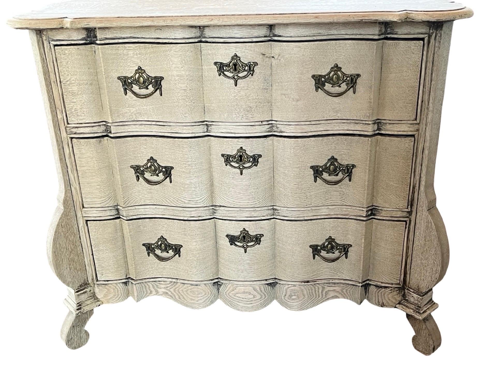 Cassettiera realizzata nei Paesi Bassi all'inizio del 1900 utilizzando il legno di Oak. La cassettiera è stata sbiancata e ora ha un bellissimo colore avorio. La piccola commode presenta tre cassetti incassati con frontali a serpentina, che seguono