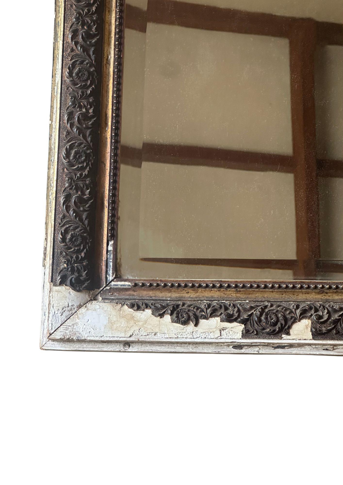 Capturant le charme raffiné du design Coloni hollandais du milieu du XXe siècle, ce miroir trumeau indonésien vintage se distingue comme une pièce décorative captivante. Fabriqué en bois de manière experte, il présente un cadre en bois richement