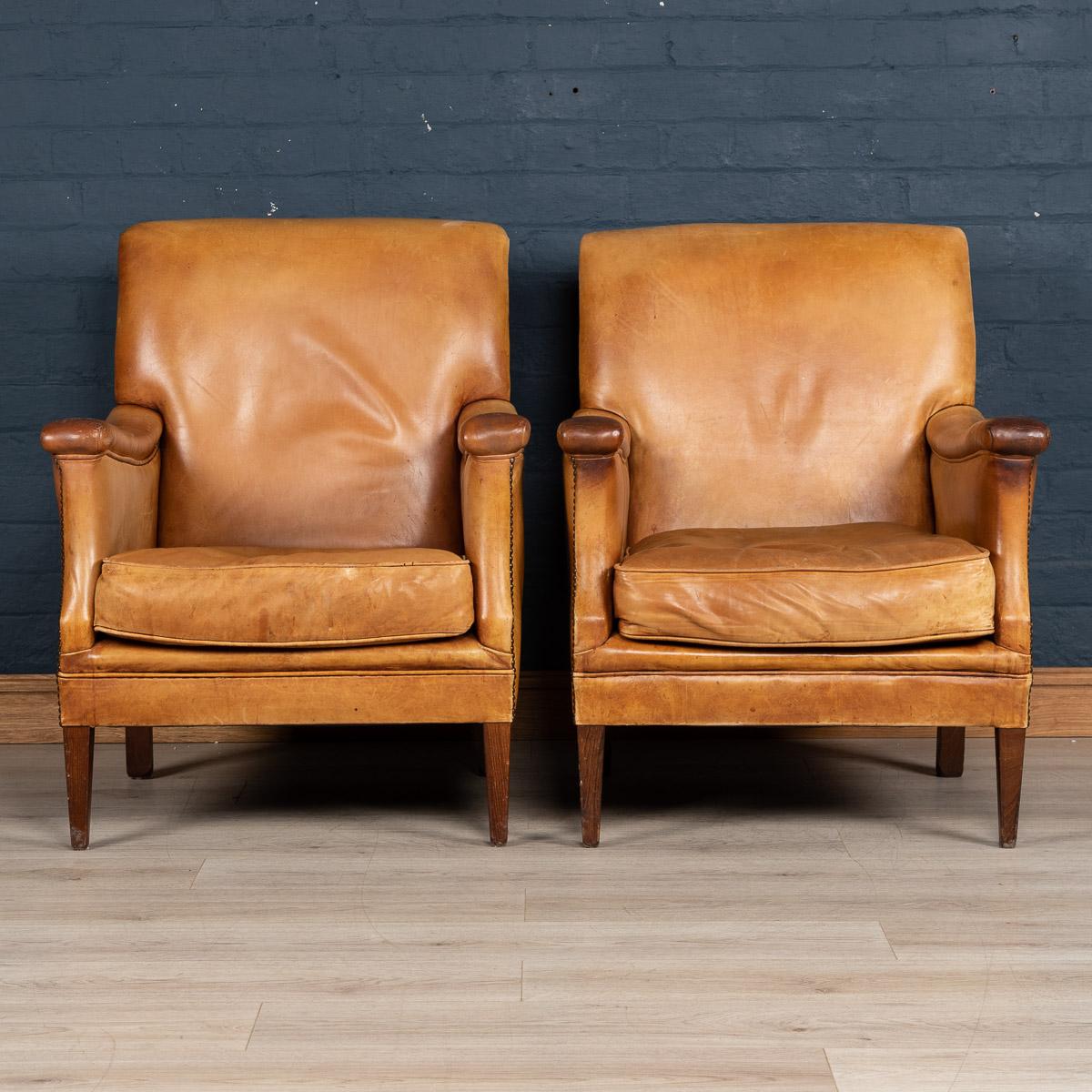 Showing superb patina and color, this wonderful pair of club chairs were hand upholstered sheepskin leather in Holland by the finest craftsmen. Fantastic look for any interior, both modern and traditional.

   