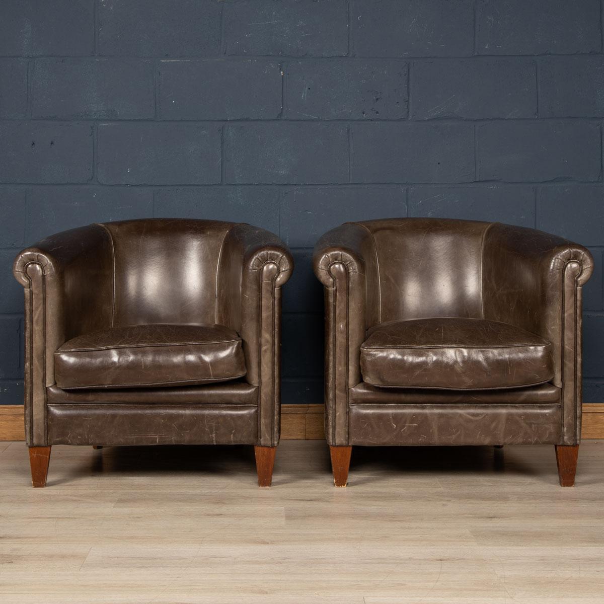 Showing superb patina and colour, this wonderful pair of club chairs were hand upholstered sheepskin leather in Holland by the finest craftsmen in the latter part of the 20th century. A distinguishing feature of these chairs is that they have a been