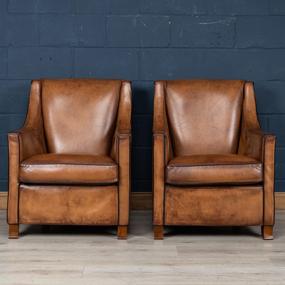 Showing superb patina and colour, this wonderful pair of club chairs were hand upholstered sheepskin leather in Holland by the finest craftsmen in the latter part of the 20th century.

The design and craftsmanship of sheep leather furniture was