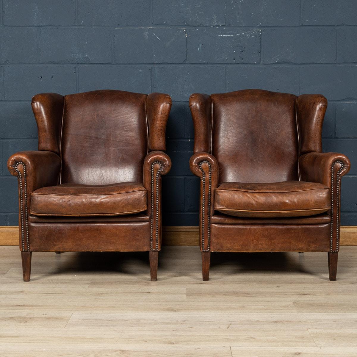 Ein wunderbares Paar lederne Ohrensessel. Die Stühle stammen aus der zweiten Hälfte des 20. Jahrhunderts und wurden von den besten niederländischen Handwerkern gefertigt, wobei der Massivholzrahmen mit hochwertigem, honigfarbenem Schafsleder