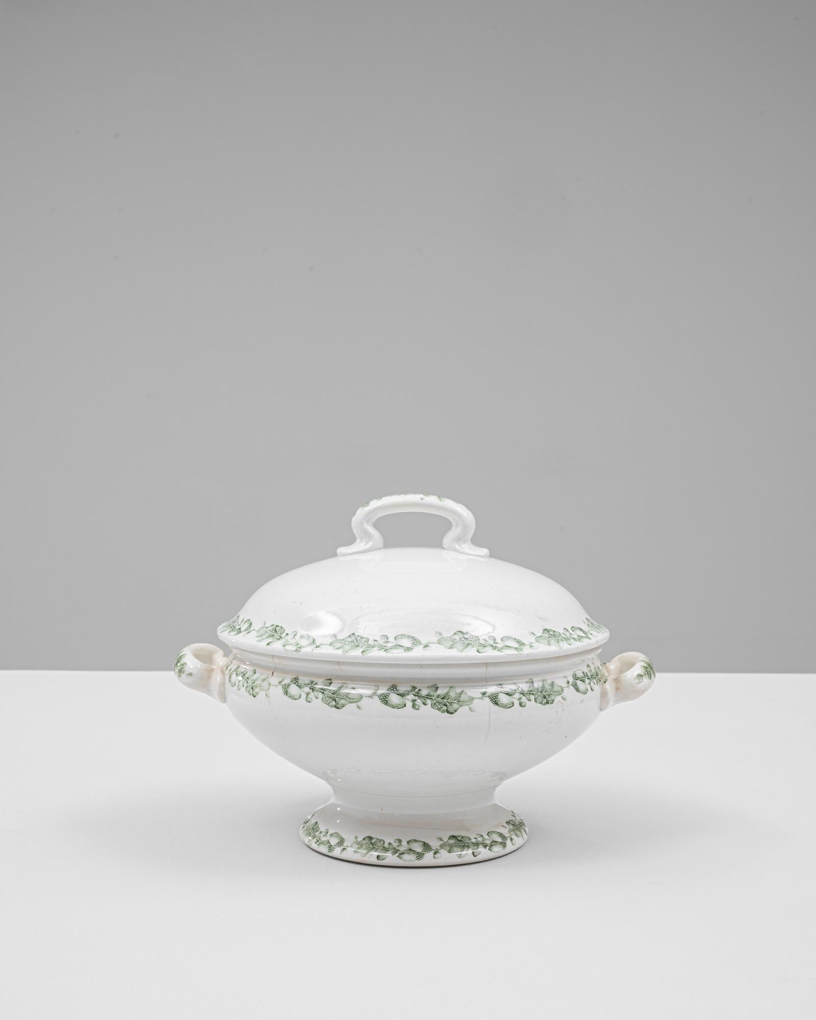 Cette soupière en porcelaine hollandaise d'édition spéciale du XXe siècle présente une élégante silhouette ovale rehaussée d'un délicat décor floral vert. Son socle légèrement évasé et ses poignées gracieusement incurvées lui confèrent un équilibre