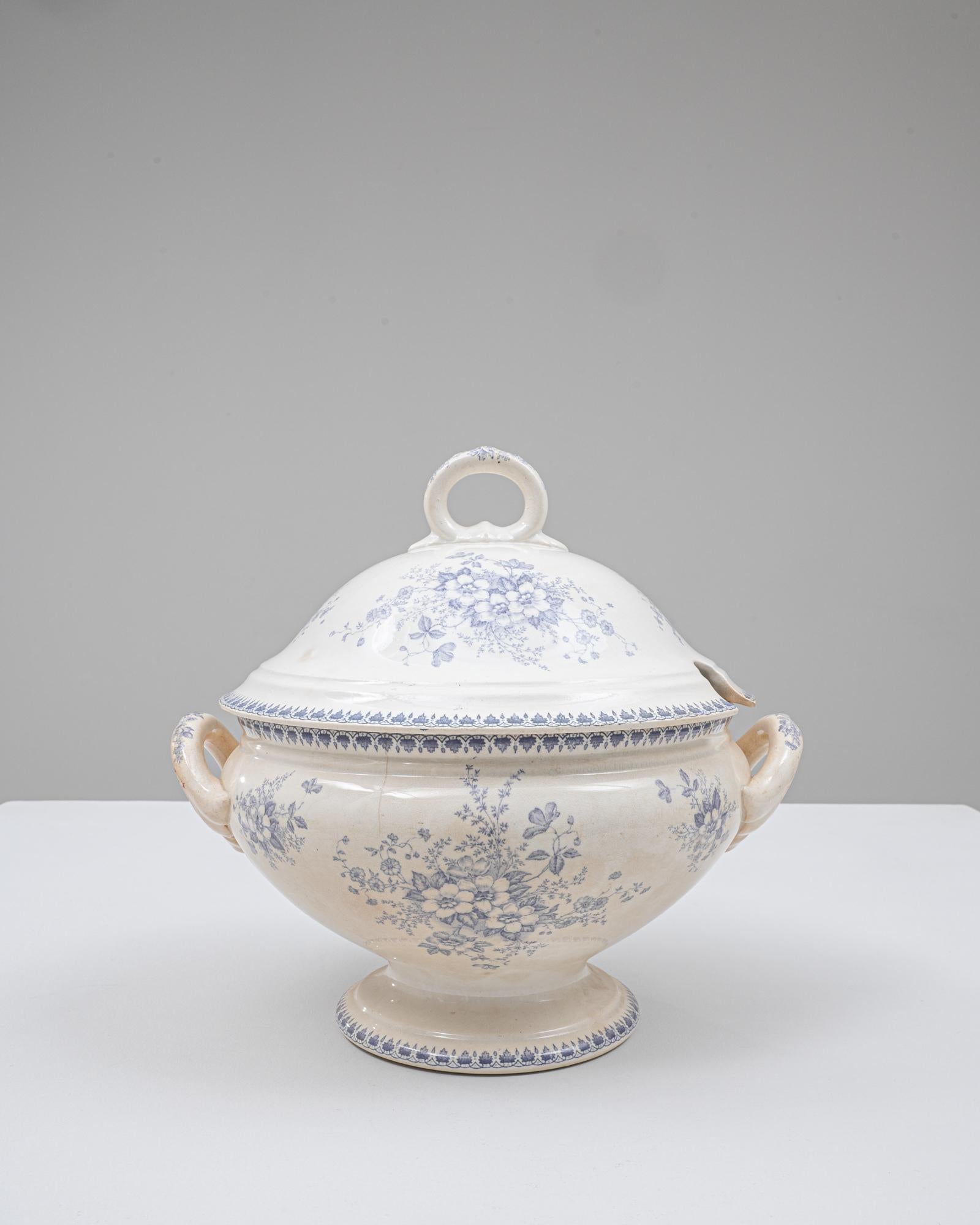 Cette soupière en porcelaine hollandaise du 20e siècle, édition spéciale, présente une silhouette joliment arrondie, sur pied, ornée de doux motifs floraux bleus transférés qui s'enroulent gracieusement sur le corps et le couvercle. La glaçure