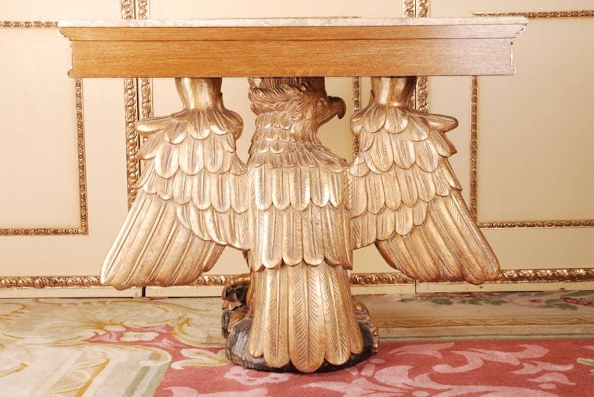 Imposing eagle console after a model by William Kent, 1685-1748.
A console from the Regency period, approximately. Monumental fully moulded hand-carved eagles from solid Beech. Partial black hand-painted and gilded. Standing on a slab. Frieze of