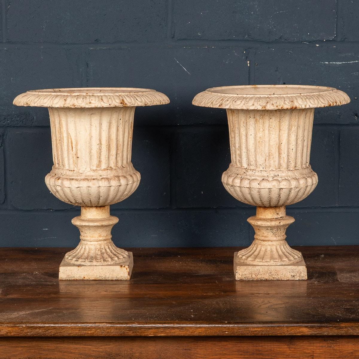 A large pair of late Edwardian English cast iron garden urns dating to the early part of the 20th Century. Of neoclassical shape, they are in lovely condition, repainted over the years which merely adds their character and charm.

Condition
In